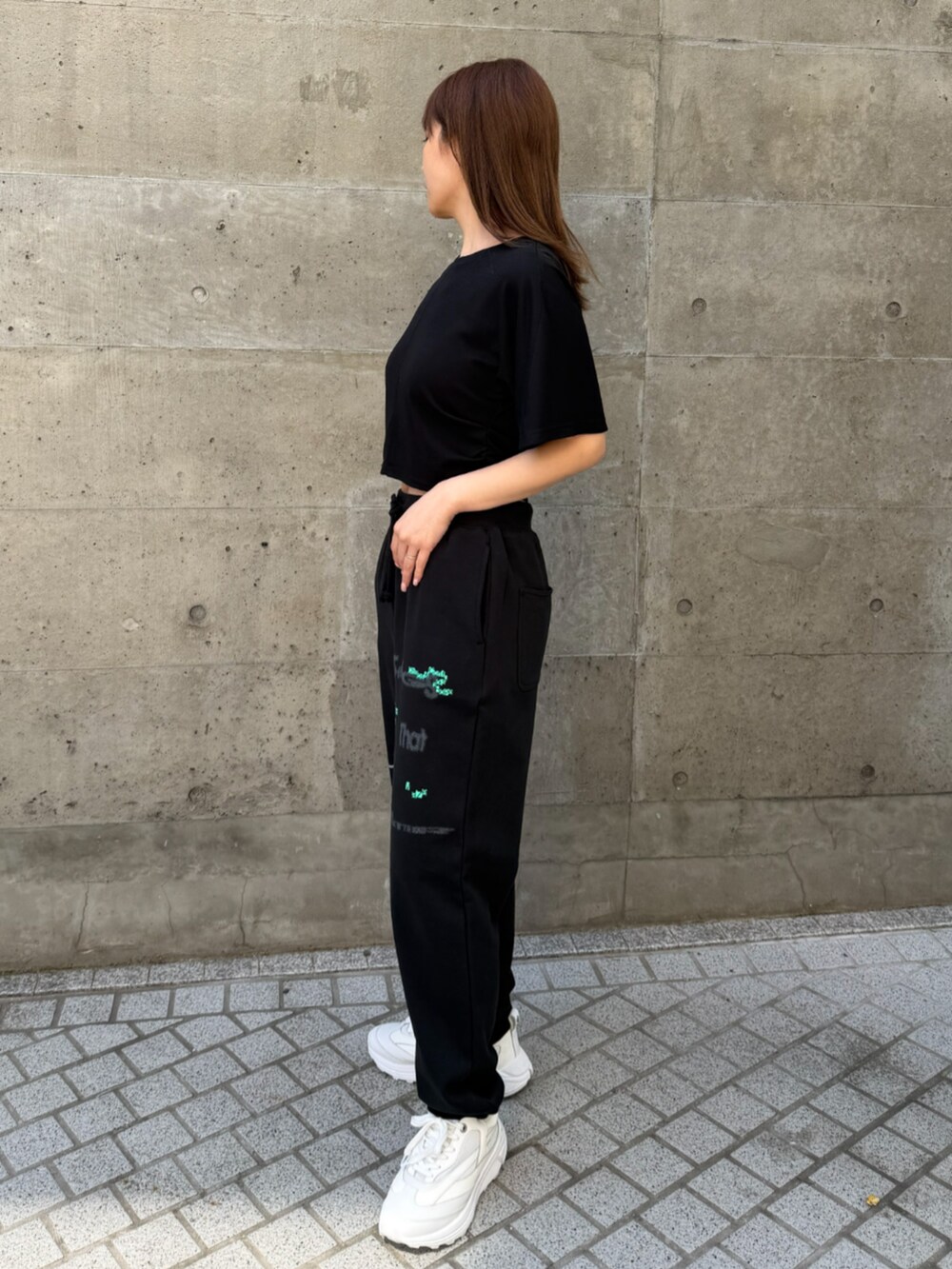 ブラック系のスウェットパンツを着用したレディースの春コーディネートの3枚目の写真