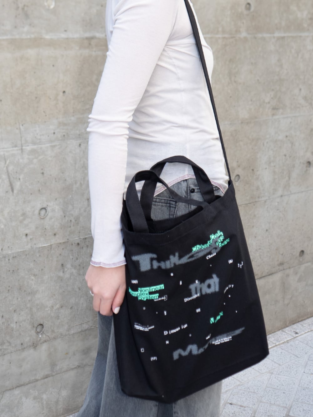 ブラック系のトートバッグを着用したレディースの冬コーディネートの2枚目の写真