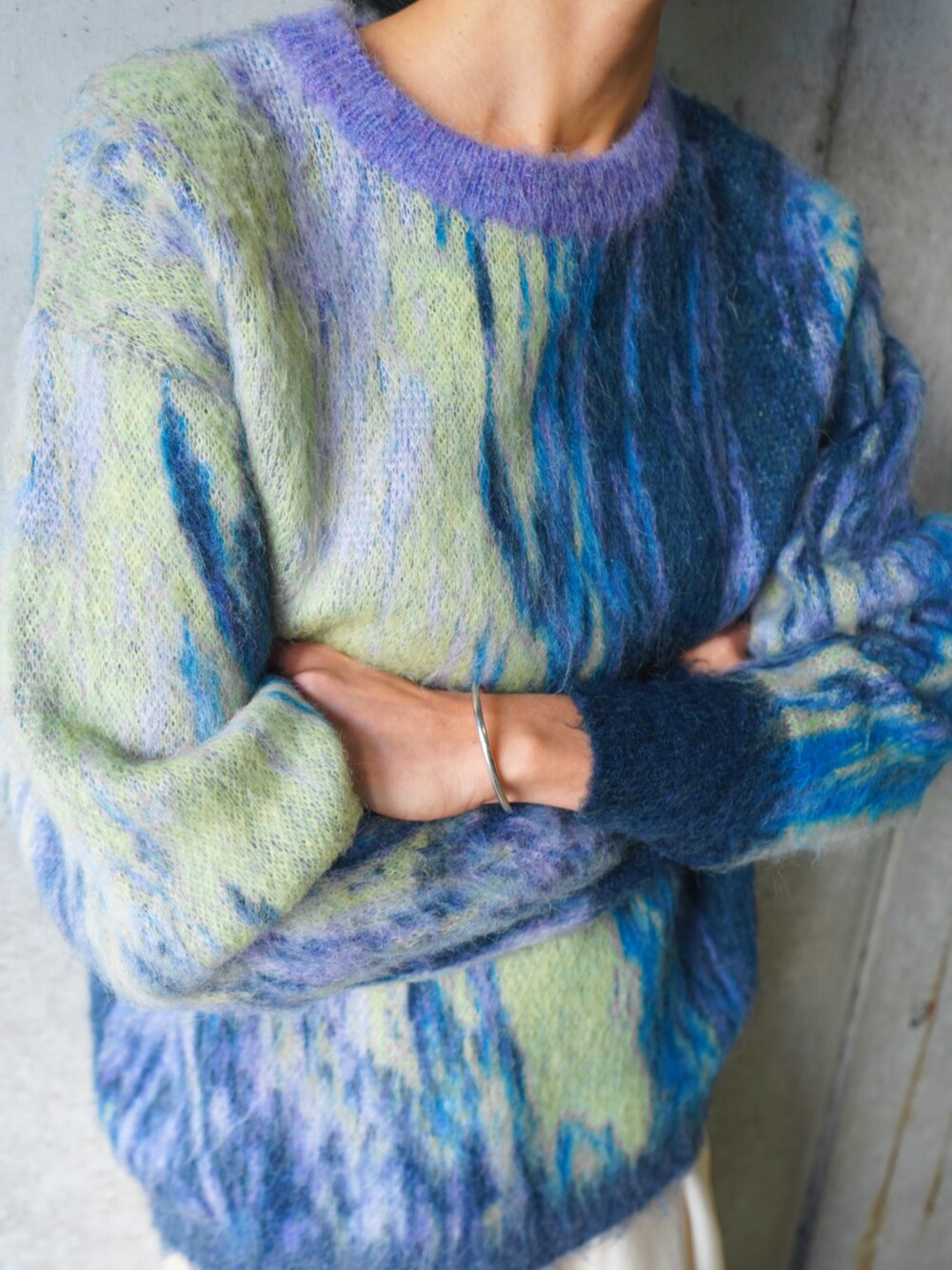 パープル系のニット/セーター、ホワイト系のその他パンツを着用したレディースの冬コーディネートの2枚目の写真