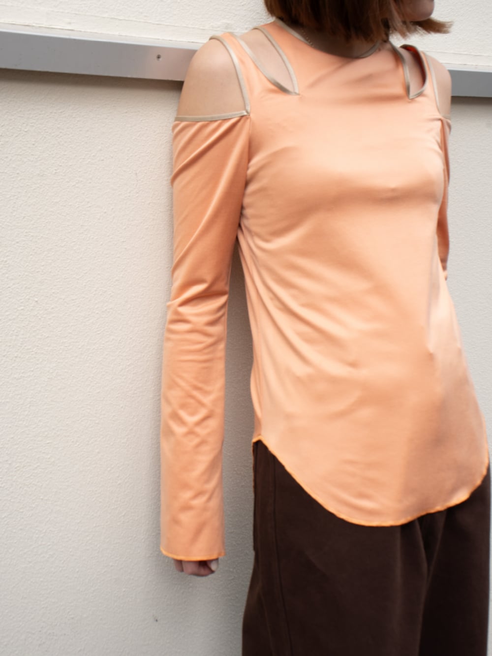 ブラウン系のデニムパンツ、オレンジ系のTシャツ/カットソーを着用したレディースの春コーディネートの2枚目の写真