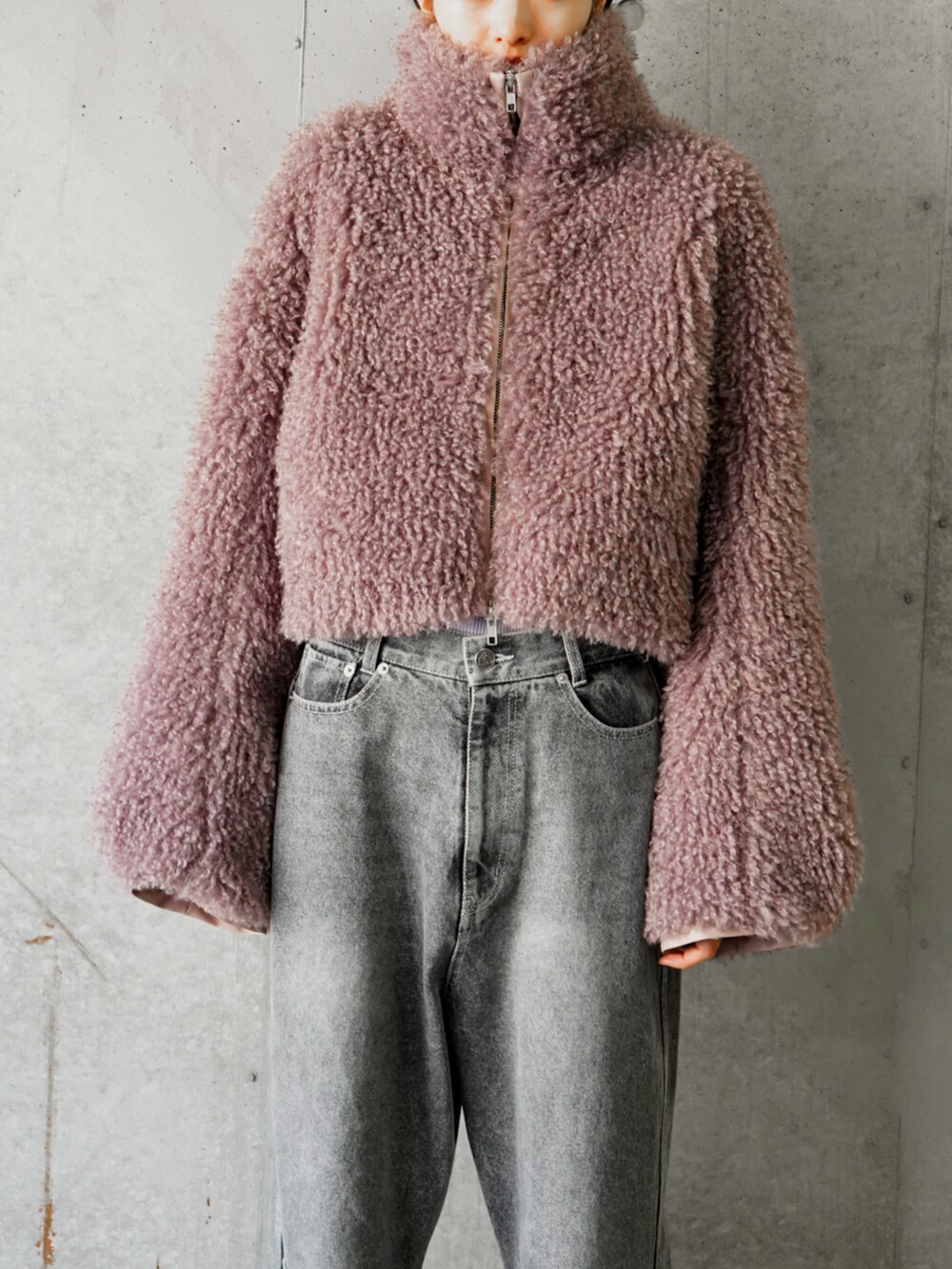 パープル系のブルゾン、ブラック系のデニムパンツを着用したレディースの冬コーディネートの4枚目の写真