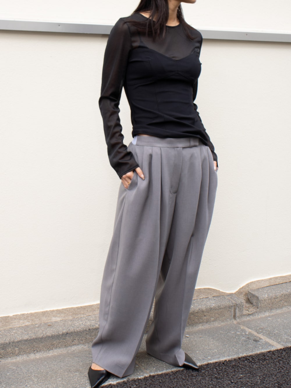 グレー系のスラックス、ブラック系のTシャツ/カットソーを着用したレディースの春コーディネートの2枚目の写真