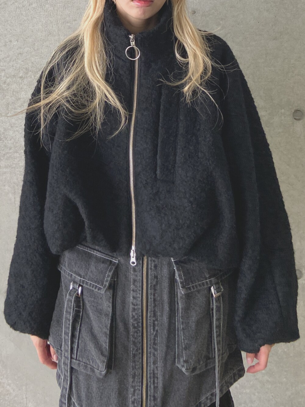 ブラック系のブルゾン、ブラック系のデニムスカートを着用したレディースの冬コーディネートの3枚目の写真