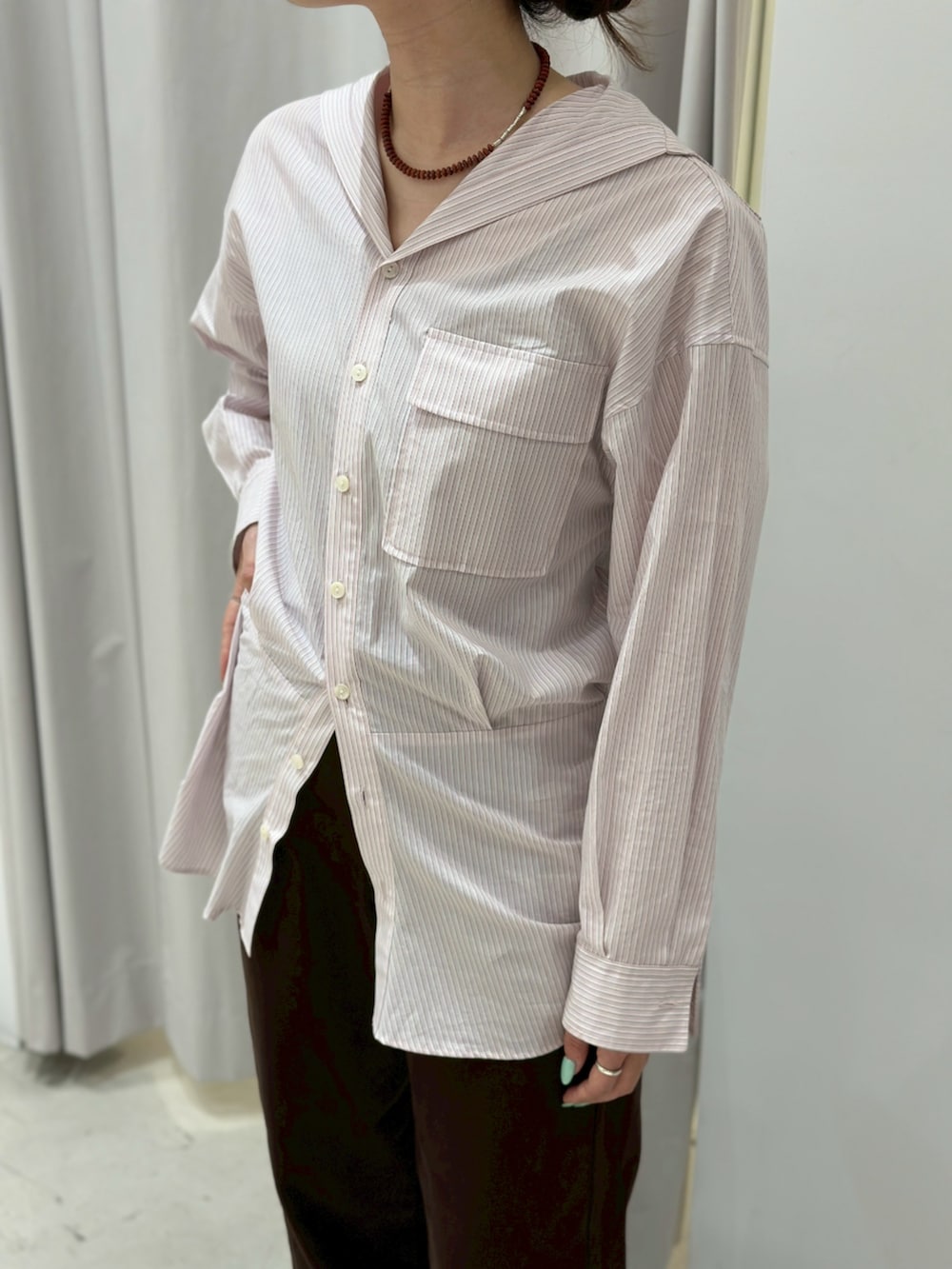 ブラウン系のデニムパンツ、ピンク系のシャツ/ブラウスを着用したレディースの春コーディネートの2枚目の写真