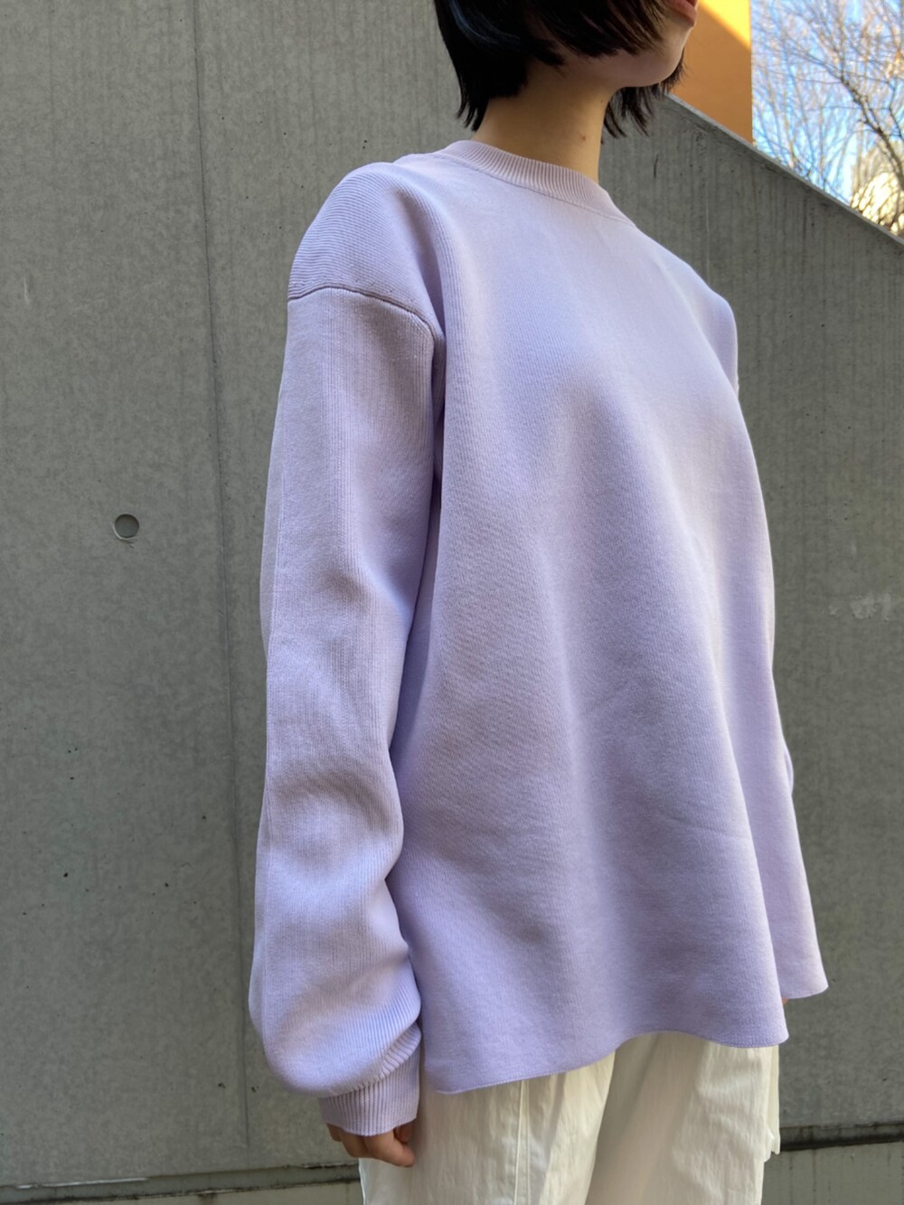 パープル系のニット/セーター、ホワイト系のカーゴパンツを着用したレディースの冬コーディネートの2枚目の写真