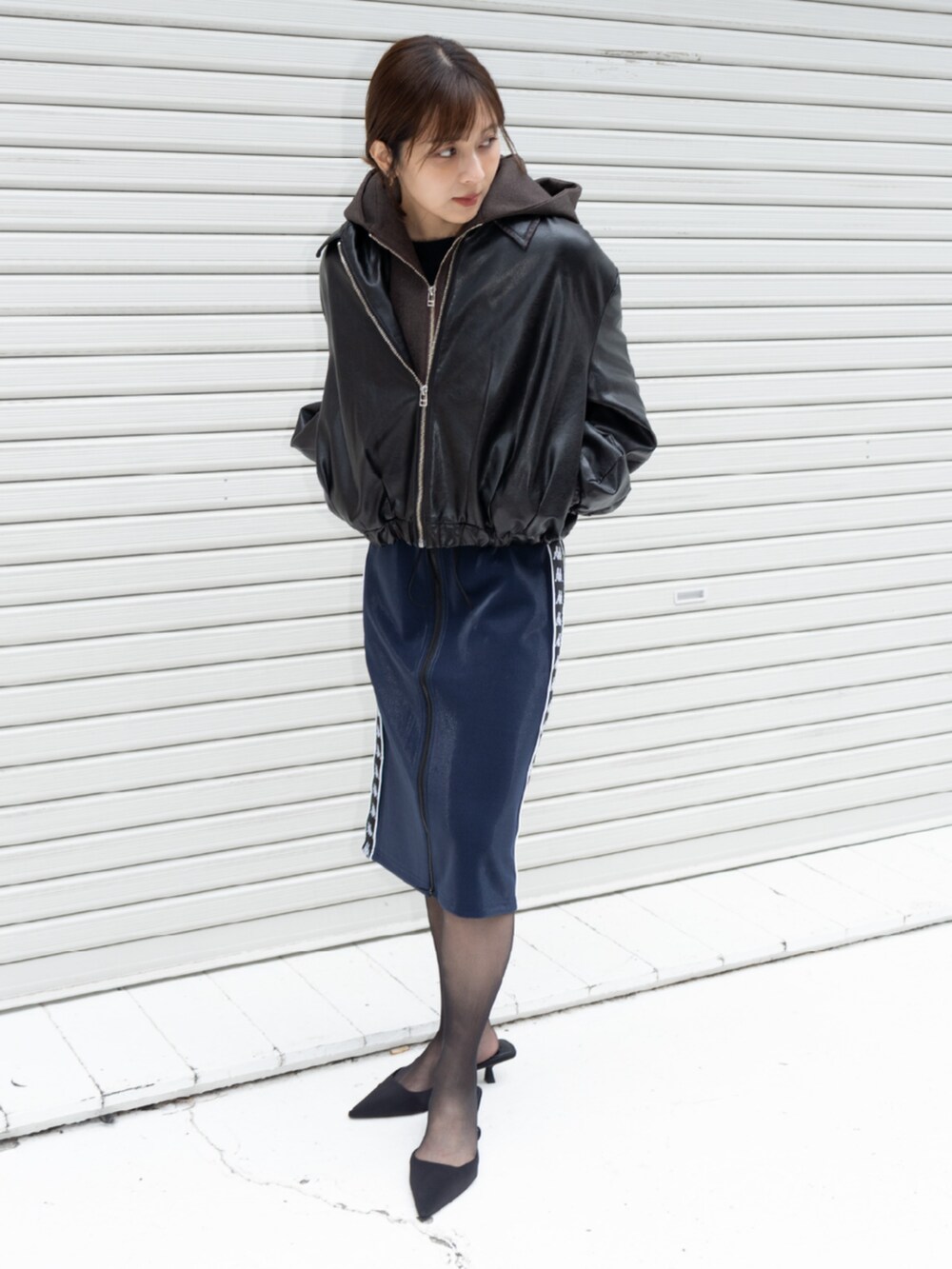 ブラウン系のブルゾン、ブルー系のスカートを着用したレディースの秋コーディネートの2枚目の写真