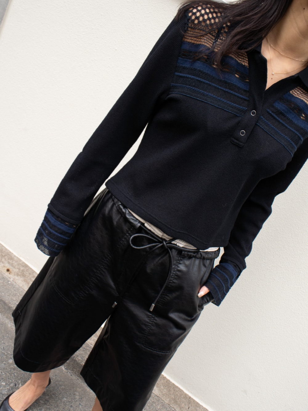 ブラック系のポロシャツ、ブラック系のその他パンツを着用したレディースの春コーディネートの2枚目の写真