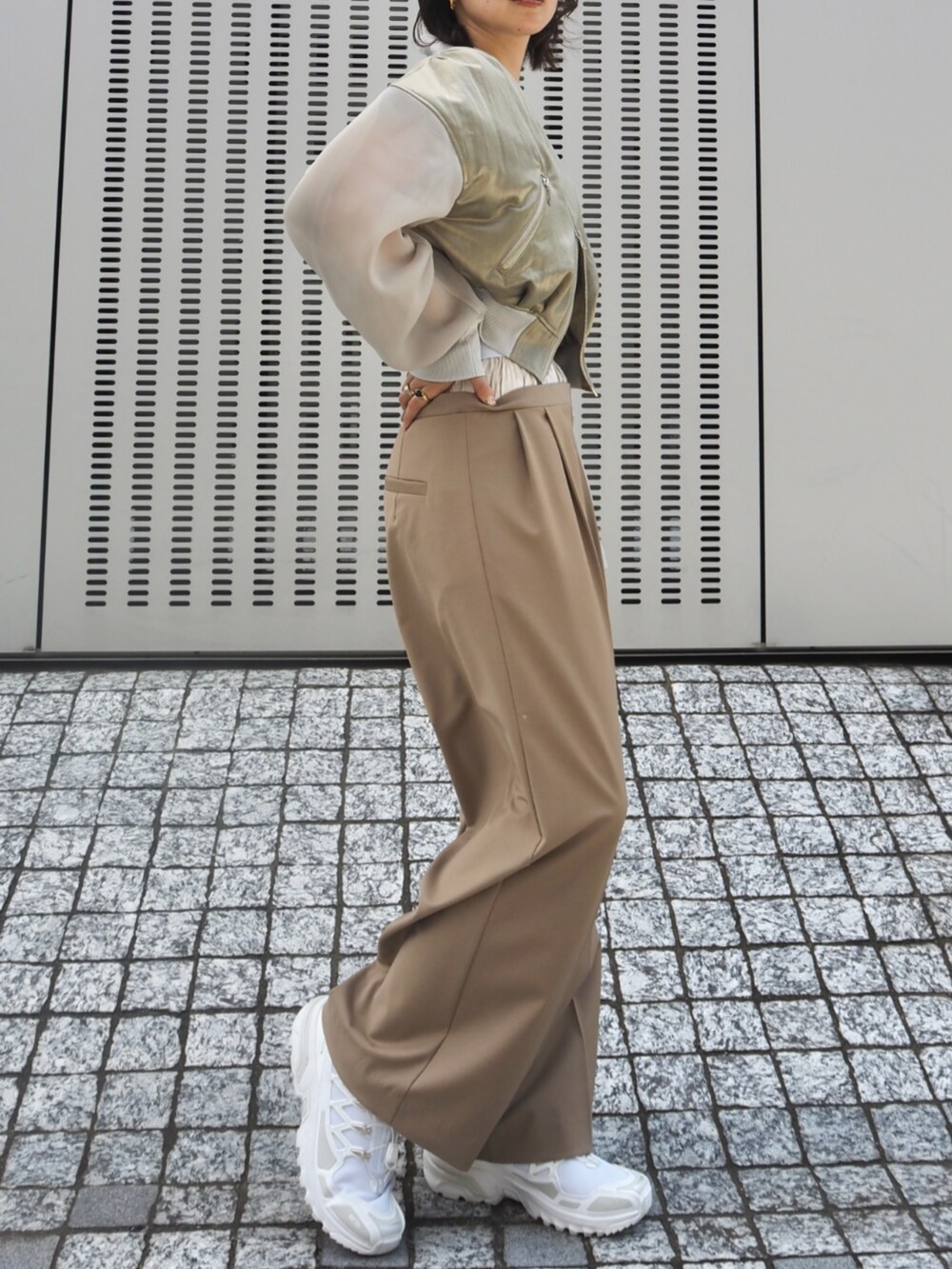 グリーン系のMA-1、ベージュ系のスラックスを着用したレディースの冬コーディネートの2枚目の写真