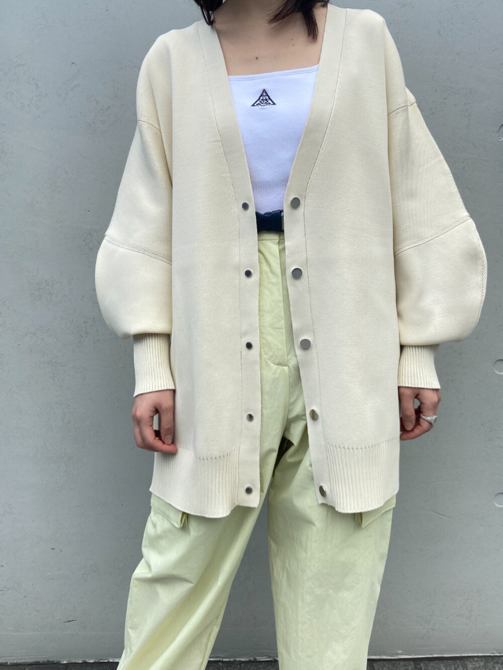 ホワイト系のカーディガン/ボレロ、イエロー系のカーゴパンツ、ホワイト系のタンクトップを着用したレディースの冬コーディネートの2枚目の写真