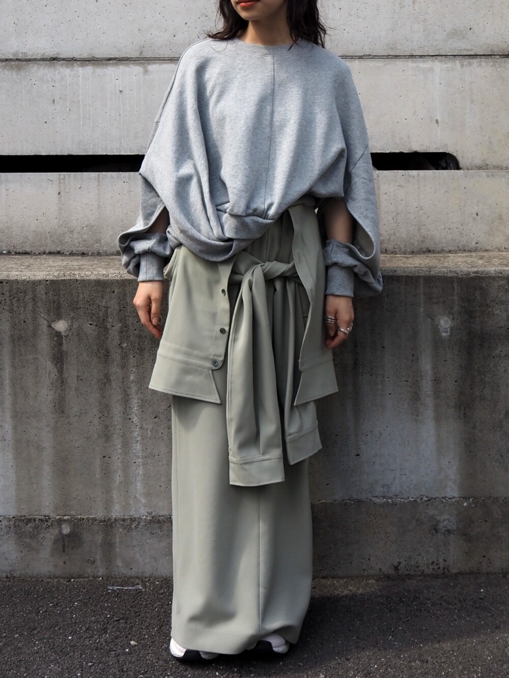 グレー系のスウェット、グリーン系のスカートを着用したレディースの冬コーディネートの2枚目の写真