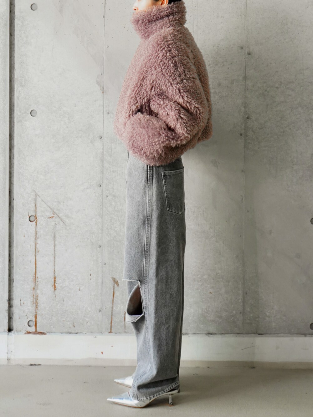 パープル系のブルゾン、ブラック系のデニムパンツを着用したレディースの冬コーディネートの2枚目の写真