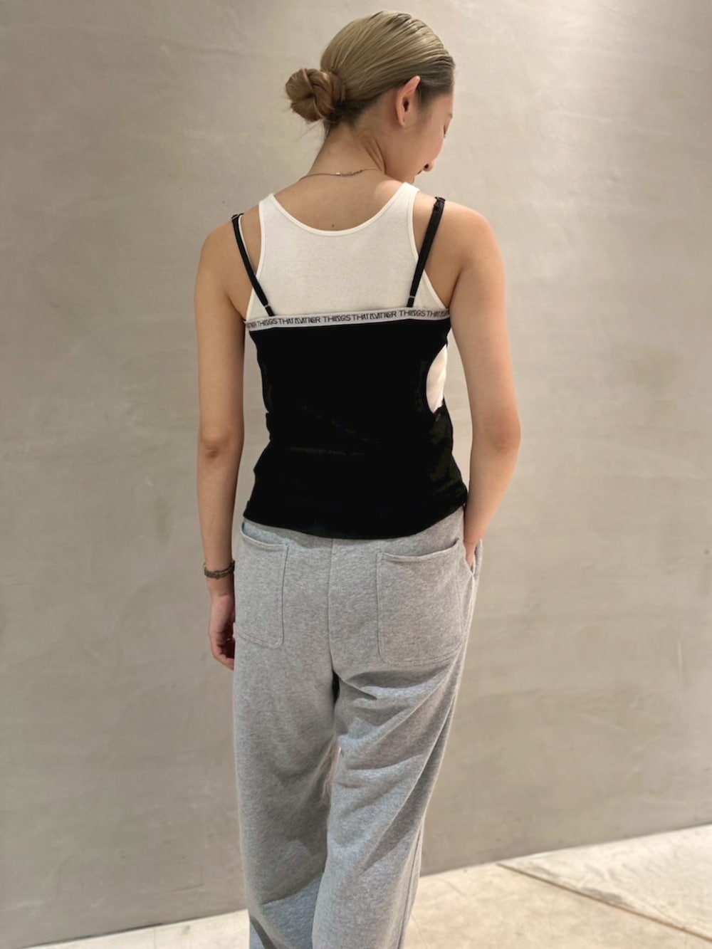 ホワイト系のタンクトップ、グレー系のスウェットパンツを着用したレディースの夏コーディネートの2枚目の写真