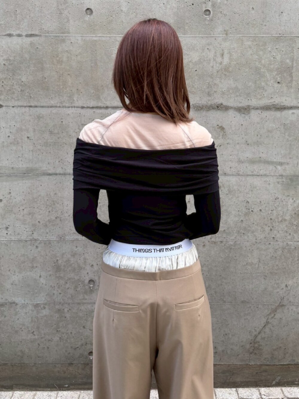 ベージュ系のスラックス、ブラック系のTシャツ/カットソーを着用したレディースの春コーディネートの3枚目の写真