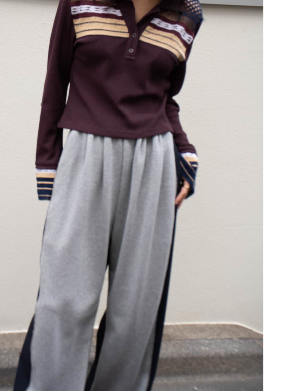 レッド系のポロシャツを着用したレディースの春コーディネートの3枚目の写真