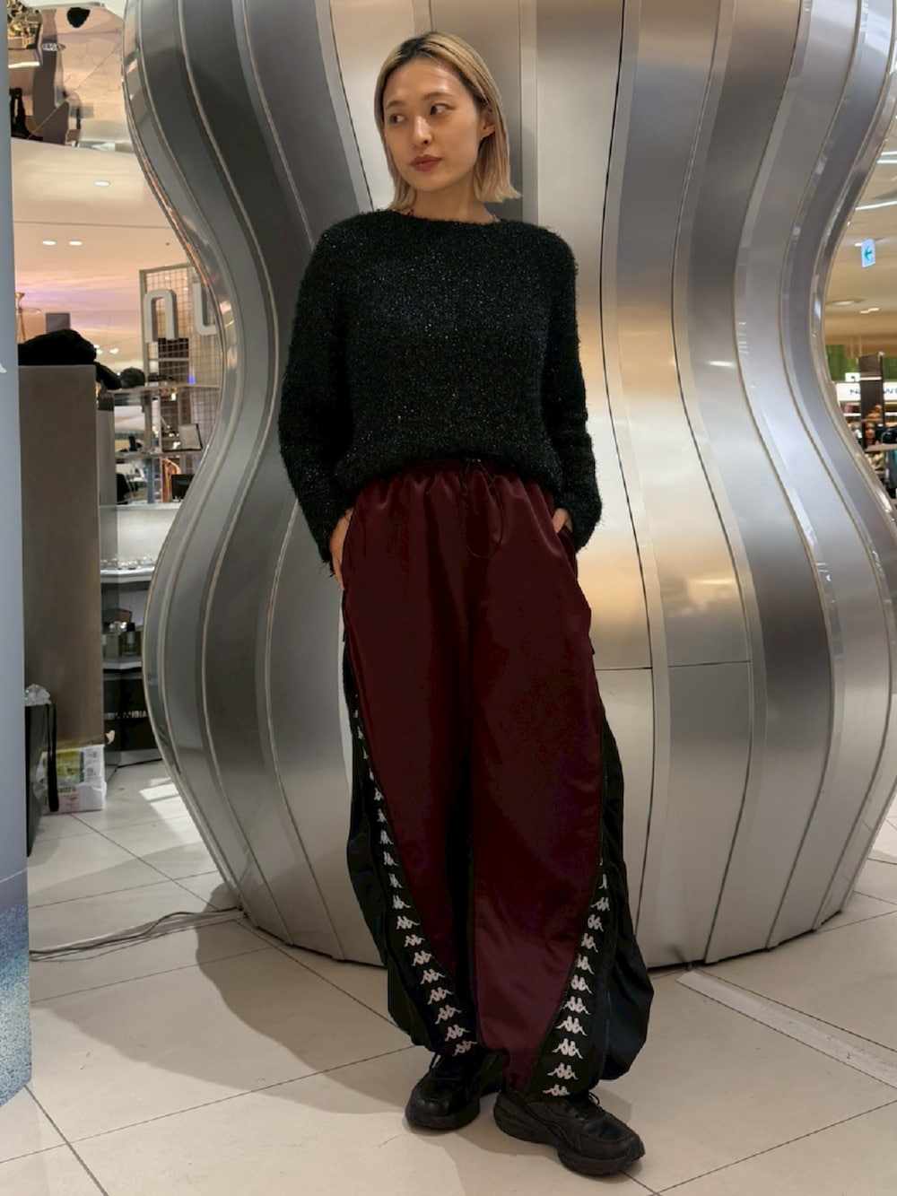 ブラック系のニット/セーター、ブルー系のその他パンツを着用したレディースの冬コーディネートの2枚目の写真