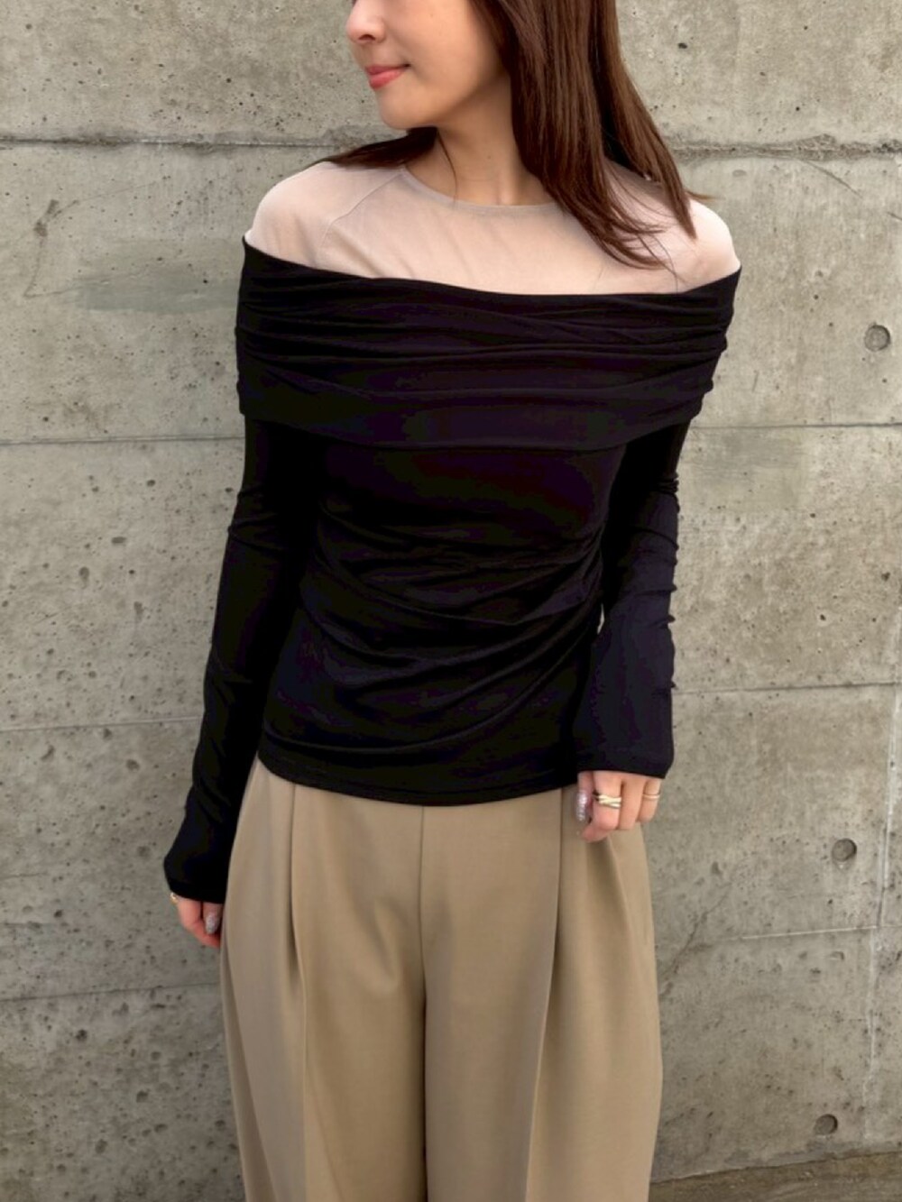 ベージュ系のスラックス、ブラック系のTシャツ/カットソーを着用したレディースの春コーディネートの2枚目の写真