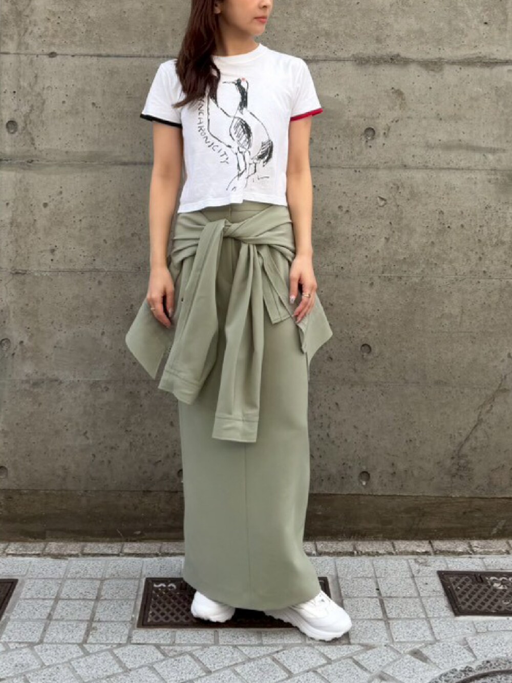 グリーン系のスカート、ホワイト系のTシャツ/カットソーを着用したレディースの春コーディネートの2枚目の写真