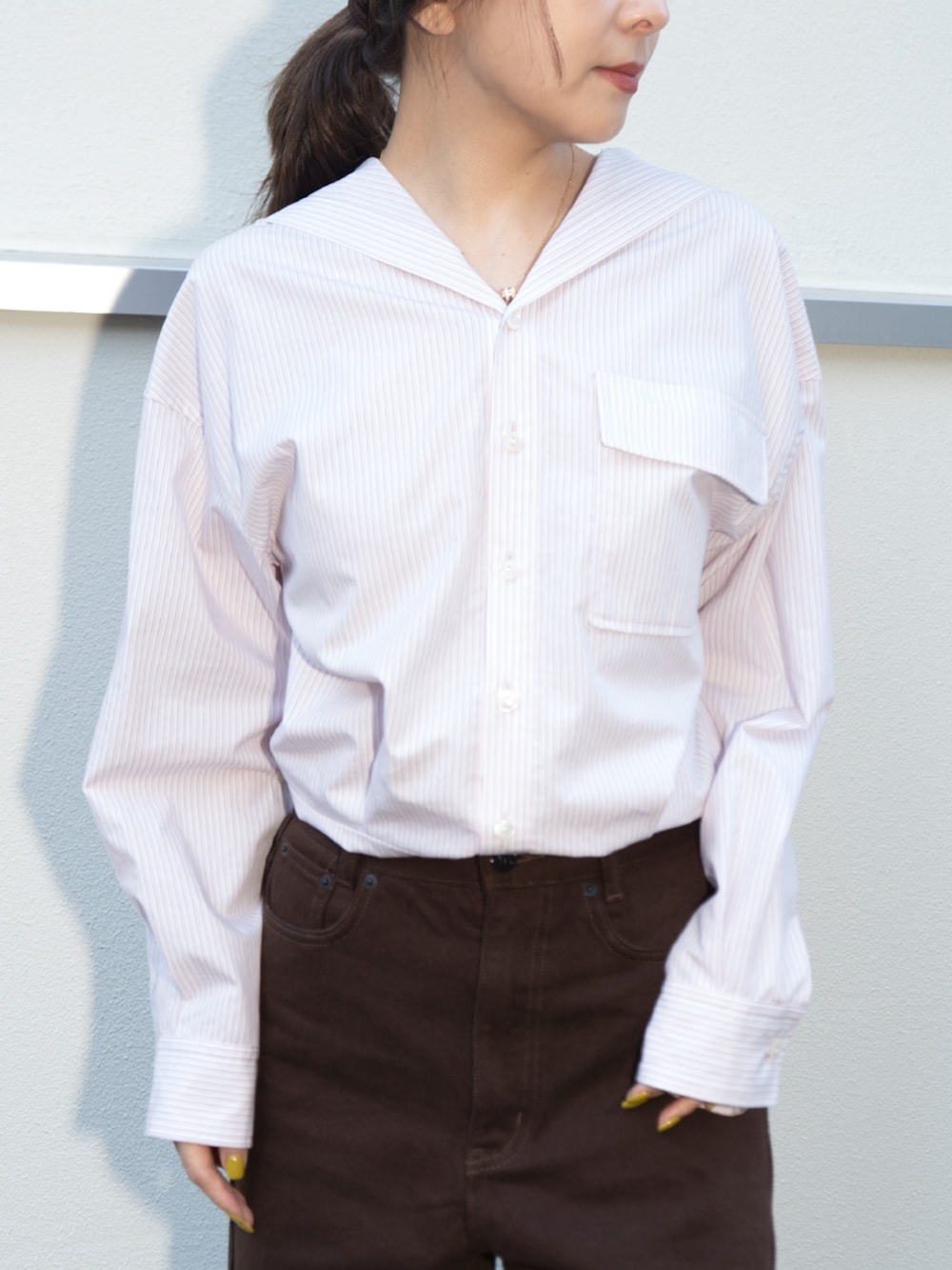 ブラウン系のデニムパンツを着用したレディースの冬コーディネートの2枚目の写真