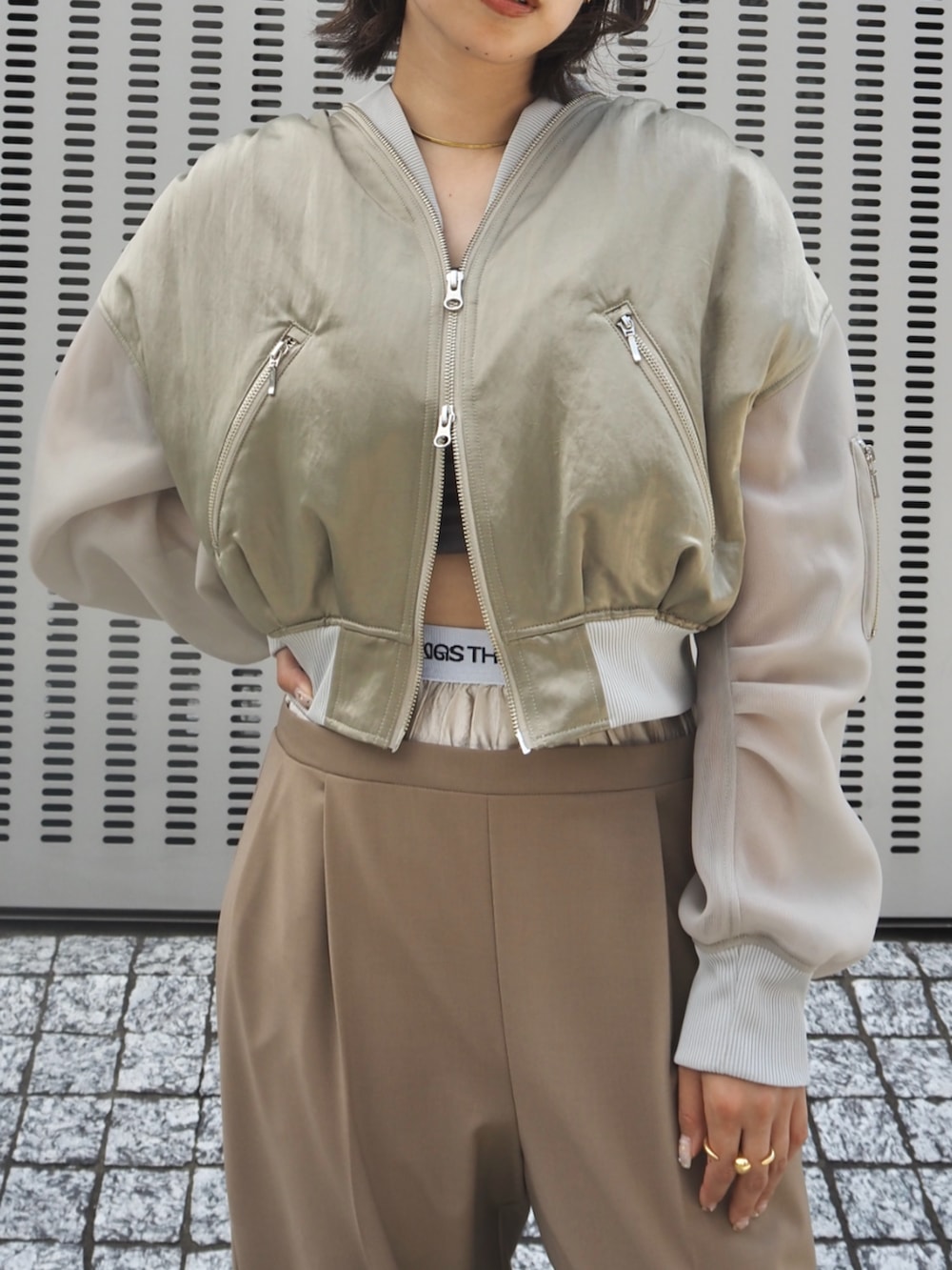 グリーン系のMA-1、ベージュ系のスラックスを着用したレディースの冬コーディネートの3枚目の写真