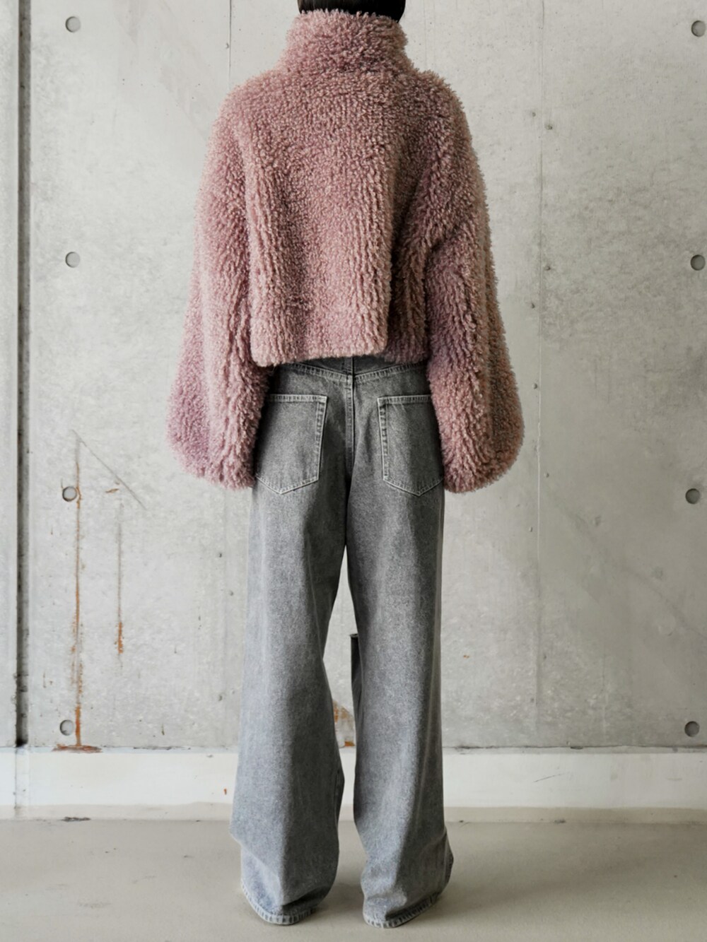 パープル系のブルゾン、ブラック系のデニムパンツを着用したレディースの冬コーディネートの3枚目の写真