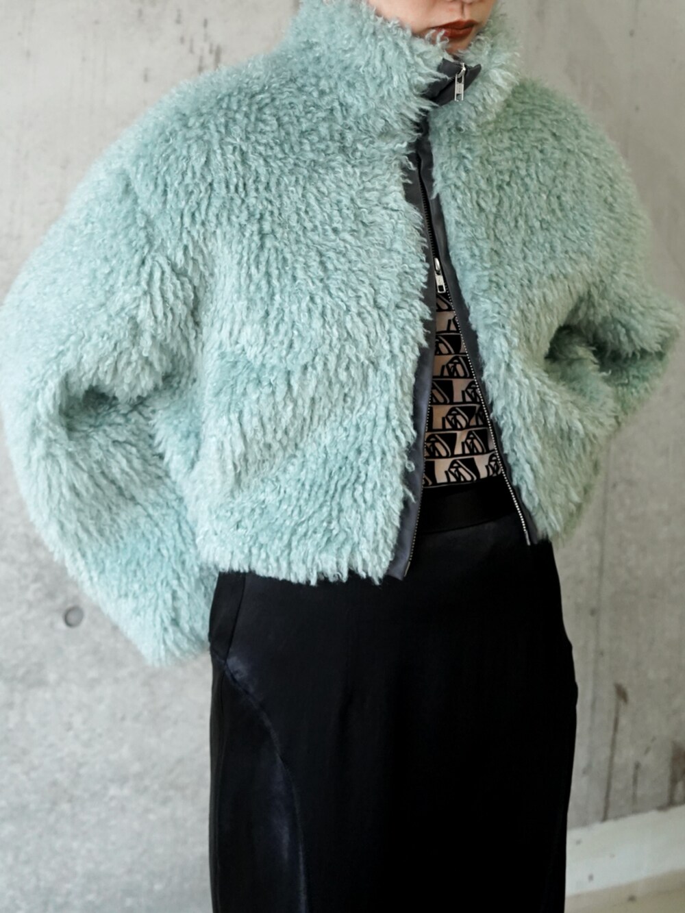 グリーン系のブルゾンを着用したレディースの冬コーディネートの2枚目の写真