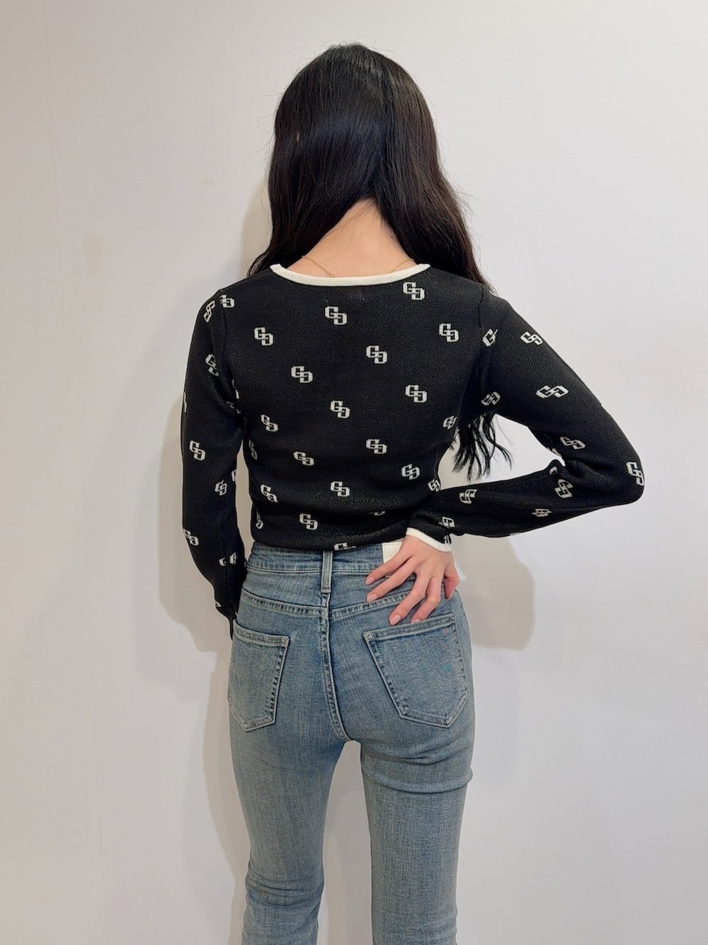 ブルー系のデニムパンツ、ブラック系のニット/セーター、ブラック系のブーツを着用したレディースの冬コーディネートの5枚目の写真