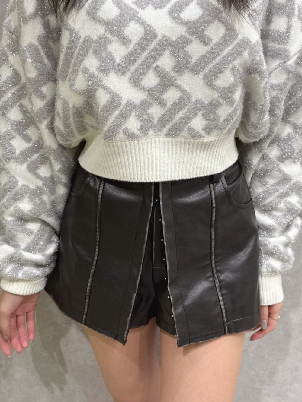ブラック系のブーツ、ブラック系のその他パンツ、ホワイト系のニット/セーターを着用したレディースの秋コーディネートの5枚目の写真