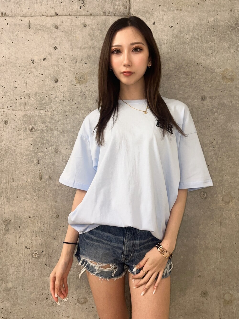 ブルー系のデニムパンツ、ブラック系のサンダル、ブルー系のTシャツ/カットソーを着用したレディースの春コーディネートの4枚目の写真