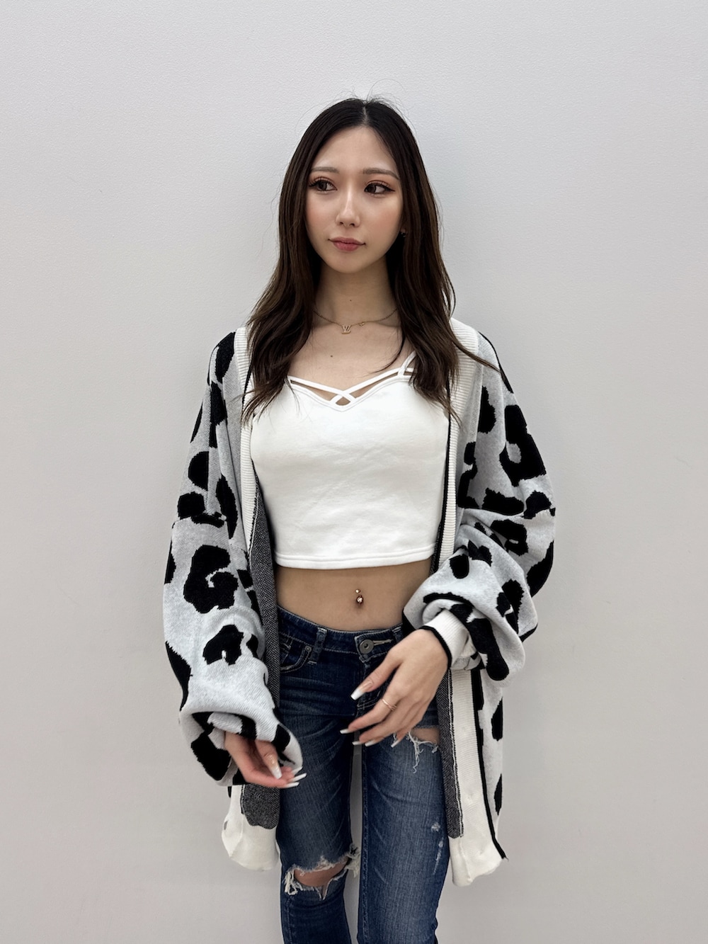 ブルー系のデニムパンツ、ブラック系のサンダル、ホワイト系のカーディガン/ボレロを着用したレディースの夏コーディネートの4枚目の写真