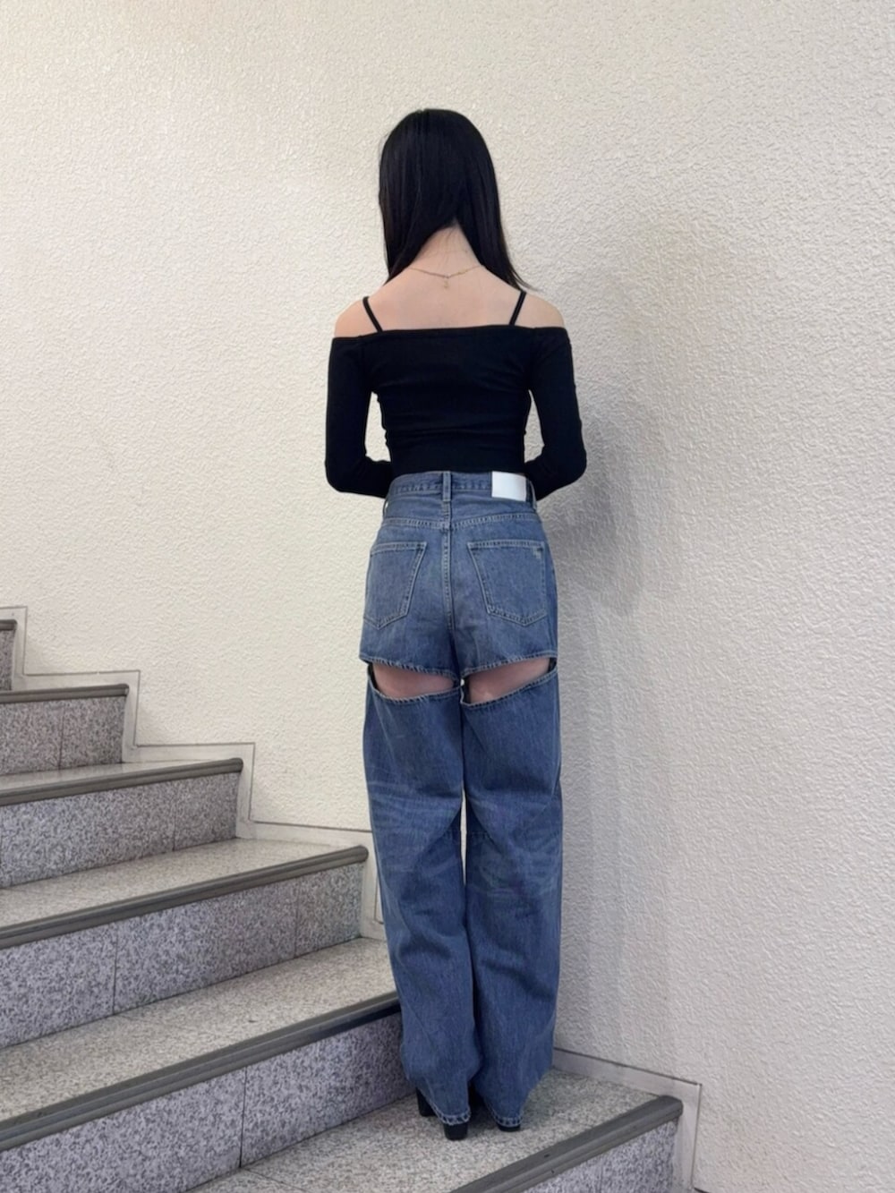 ブラック系のブーツ、ブルー系のデニムパンツ、ブラック系のTシャツ/カットソーを着用したレディースの秋コーディネートの3枚目の写真
