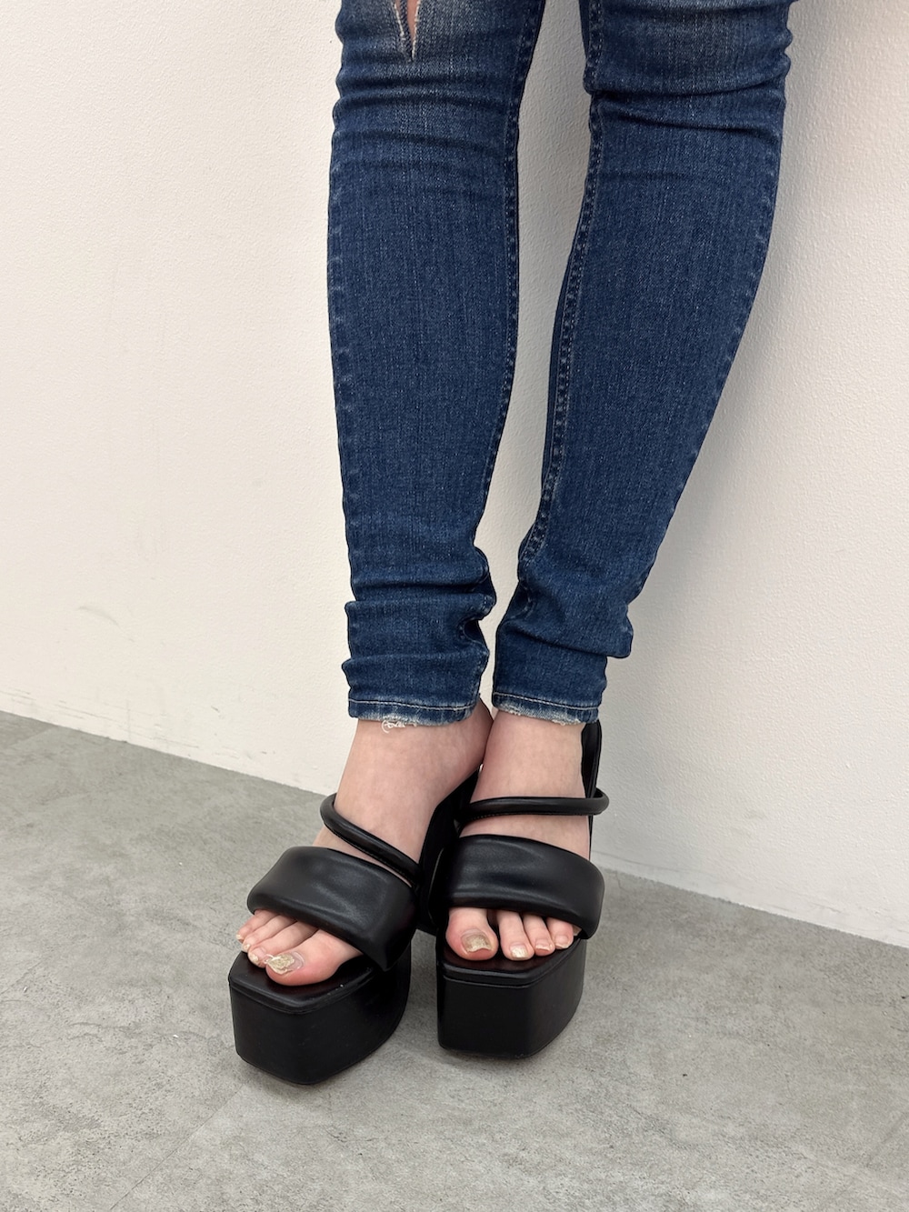 ブルー系のデニムパンツ、ブラック系のサンダル、ホワイト系のカーディガン/ボレロを着用したレディースの夏コーディネートの7枚目の写真