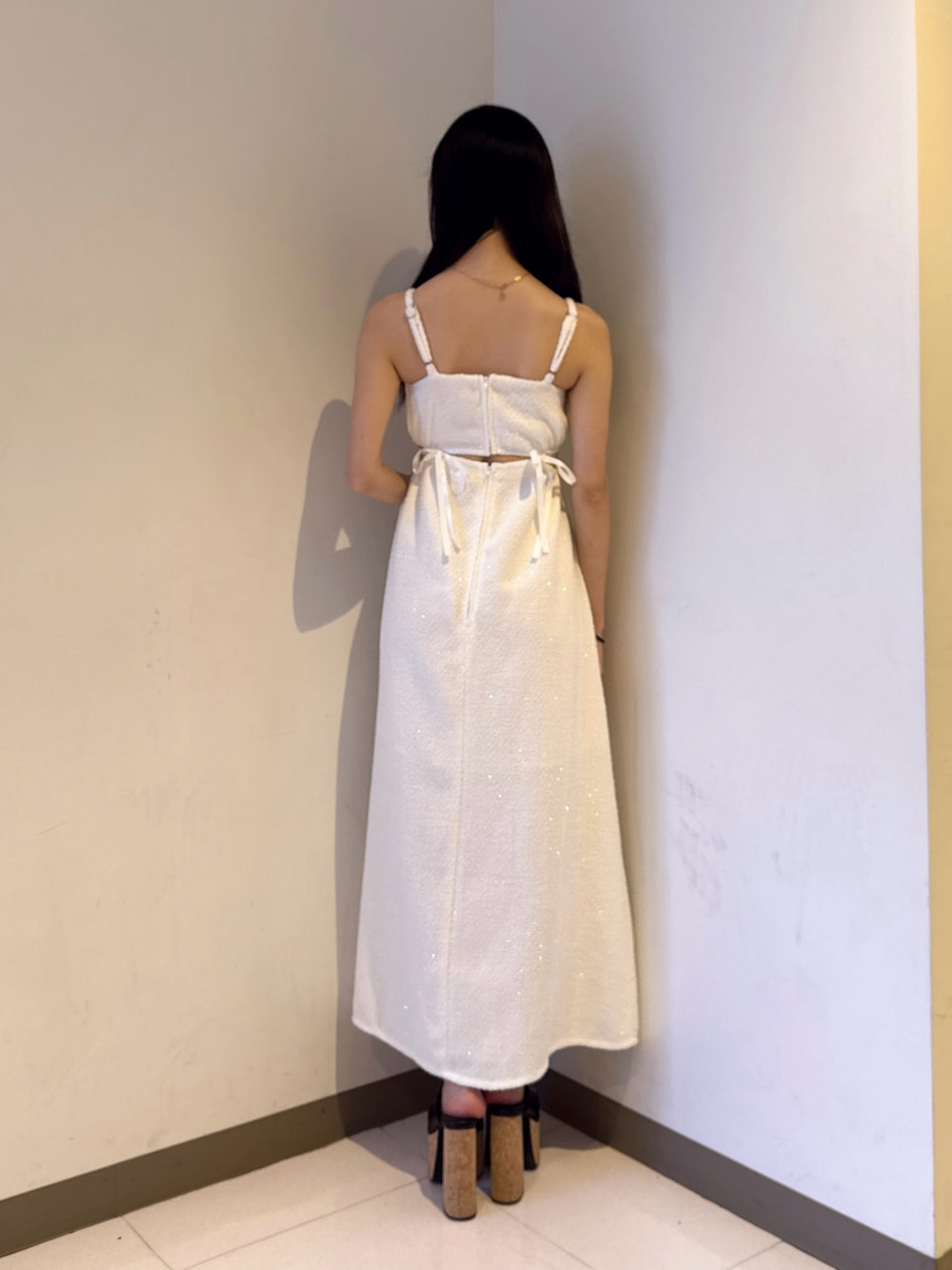 ホワイト系のワンピース、ブラック系のサンダルを着用したレディースの夏コーディネートの3枚目の写真