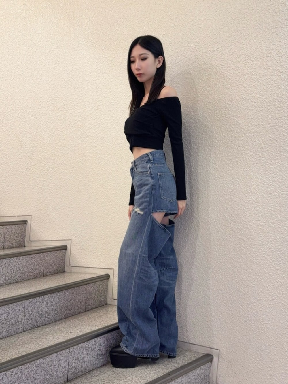 ブラック系のブーツ、ブルー系のデニムパンツ、ブラック系のTシャツ/カットソーを着用したレディースの秋コーディネートの2枚目の写真