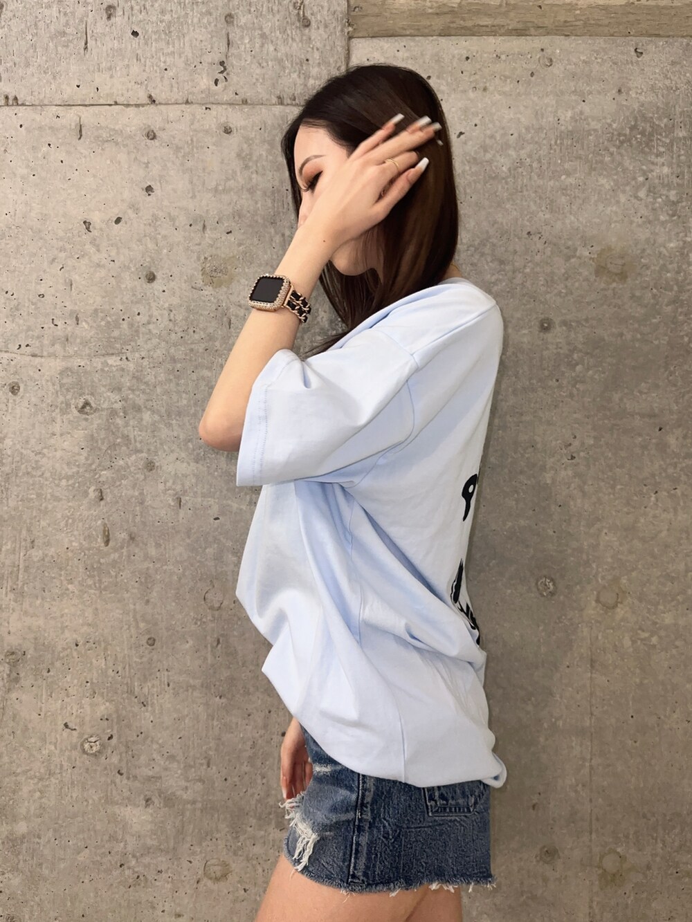 ブルー系のデニムパンツ、ブラック系のサンダル、ブルー系のTシャツ/カットソーを着用したレディースの春コーディネートの6枚目の写真