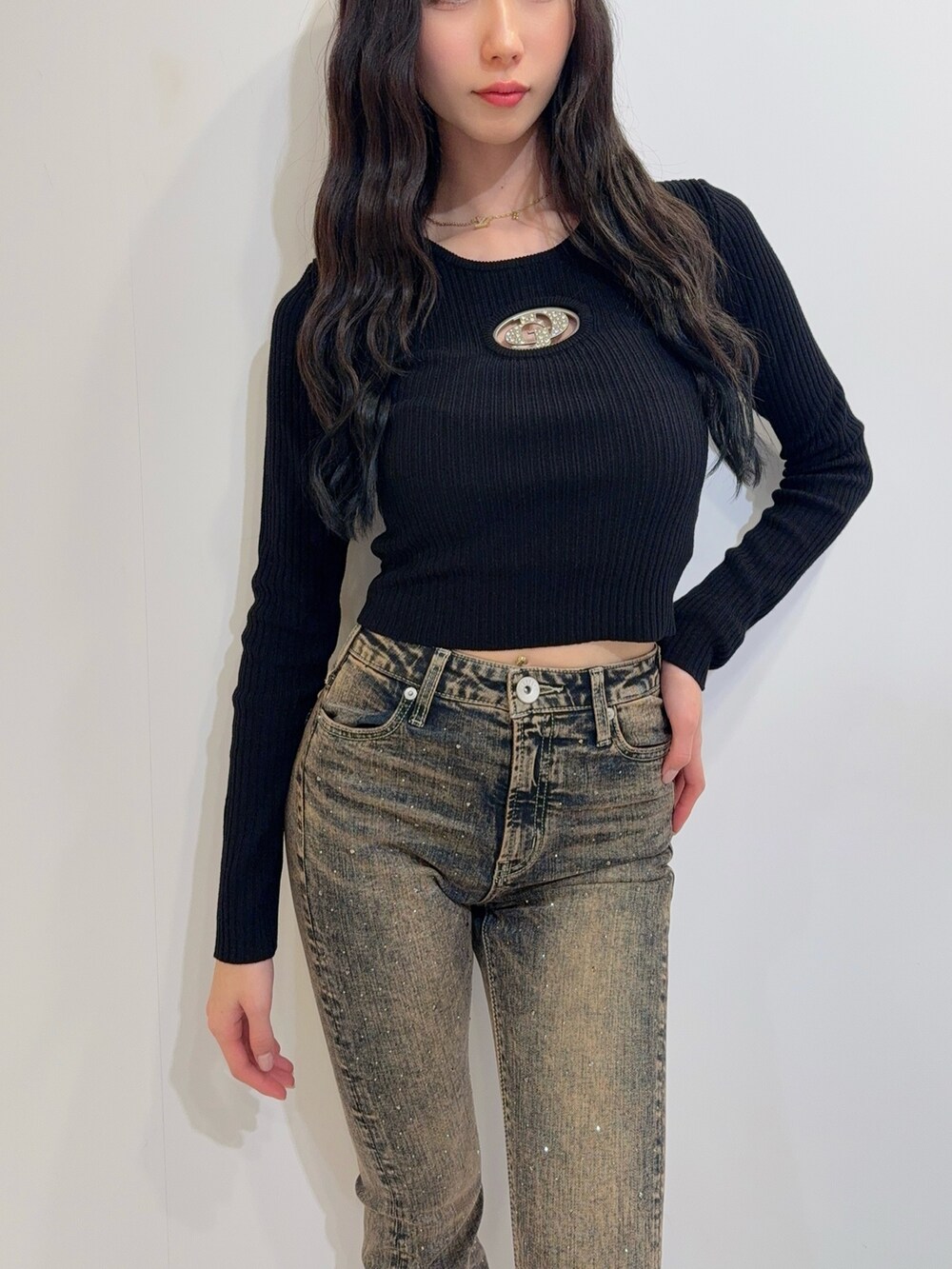 ブルー系のデニムパンツ、ブラック系のニット/セーター、ブラック系のブーツを着用したレディースの冬コーディネートの5枚目の写真