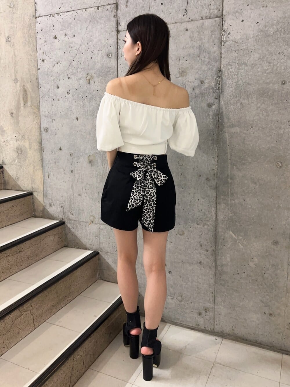 ブラック系のサンダル、ブラック系のその他パンツ、ホワイト系のシャツ/ブラウスを着用したレディースの夏コーディネートの2枚目の写真