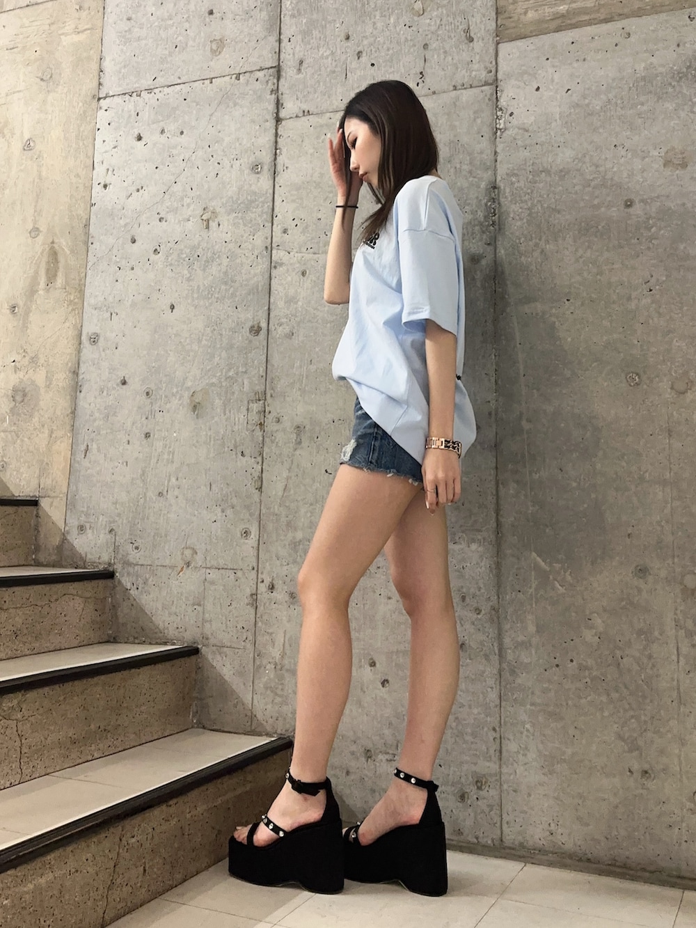 ブルー系のデニムパンツ、ブラック系のサンダル、ブルー系のTシャツ/カットソーを着用したレディースの春コーディネートの2枚目の写真