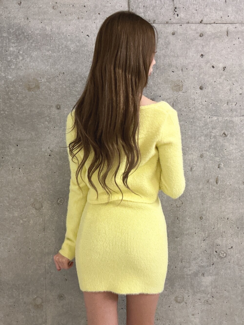 イエロー系のワンピース、イエロー系のカーディガン/ボレロ、ホワイト系のブーツを着用したレディースの冬コーディネートの5枚目の写真