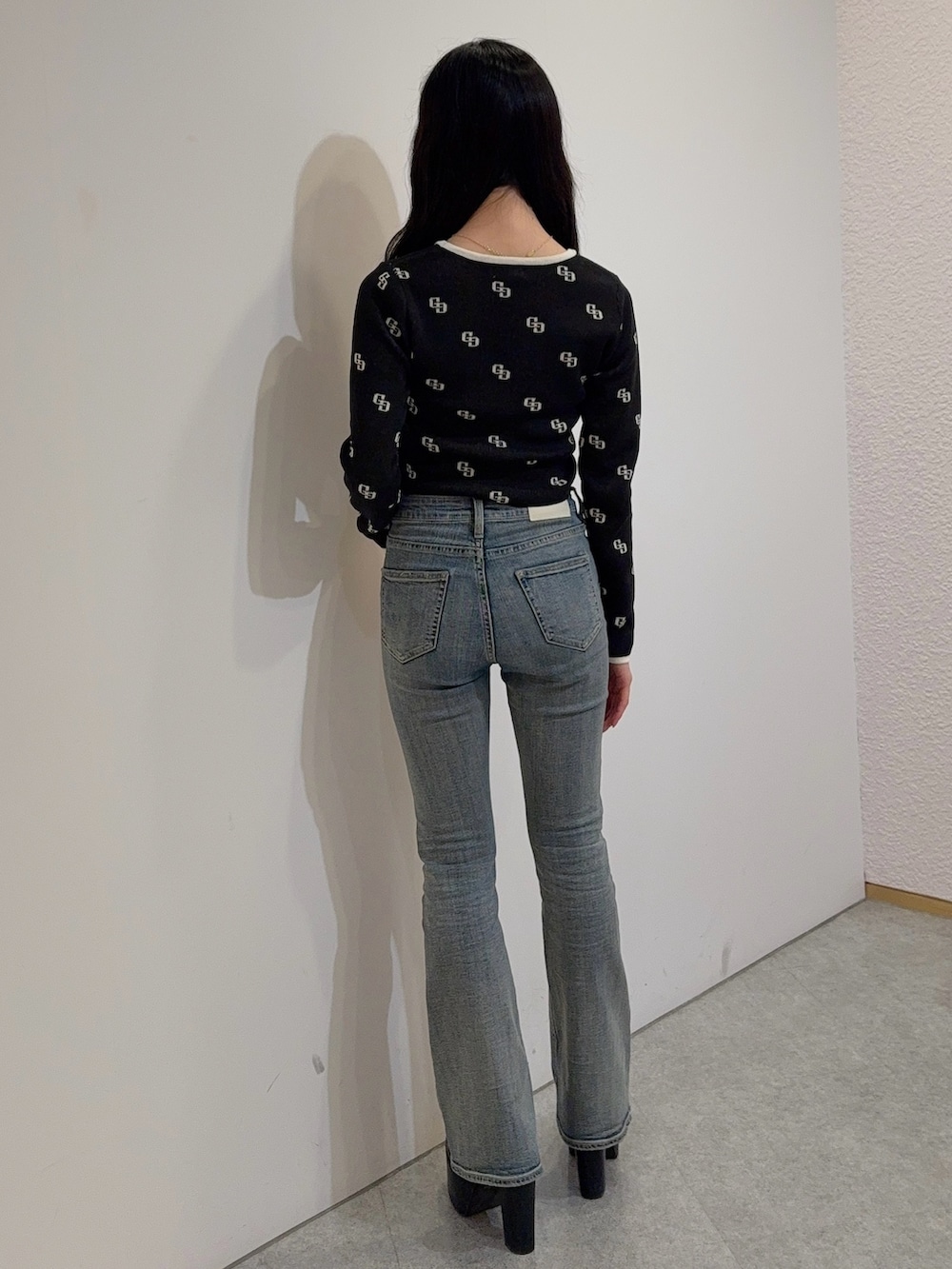 ブルー系のデニムパンツ、ブラック系のニット/セーター、ブラック系のブーツを着用したレディースの冬コーディネートの3枚目の写真