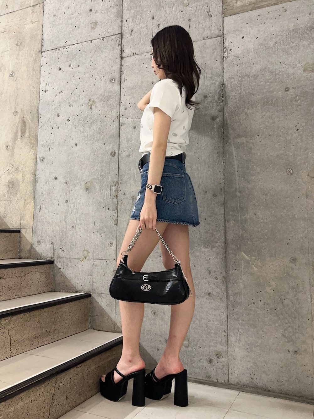 ブルー系のデニムスカート、ホワイト系のTシャツ/カットソー、ブラック系のサンダルを着用したレディースの春コーディネートの2枚目の写真