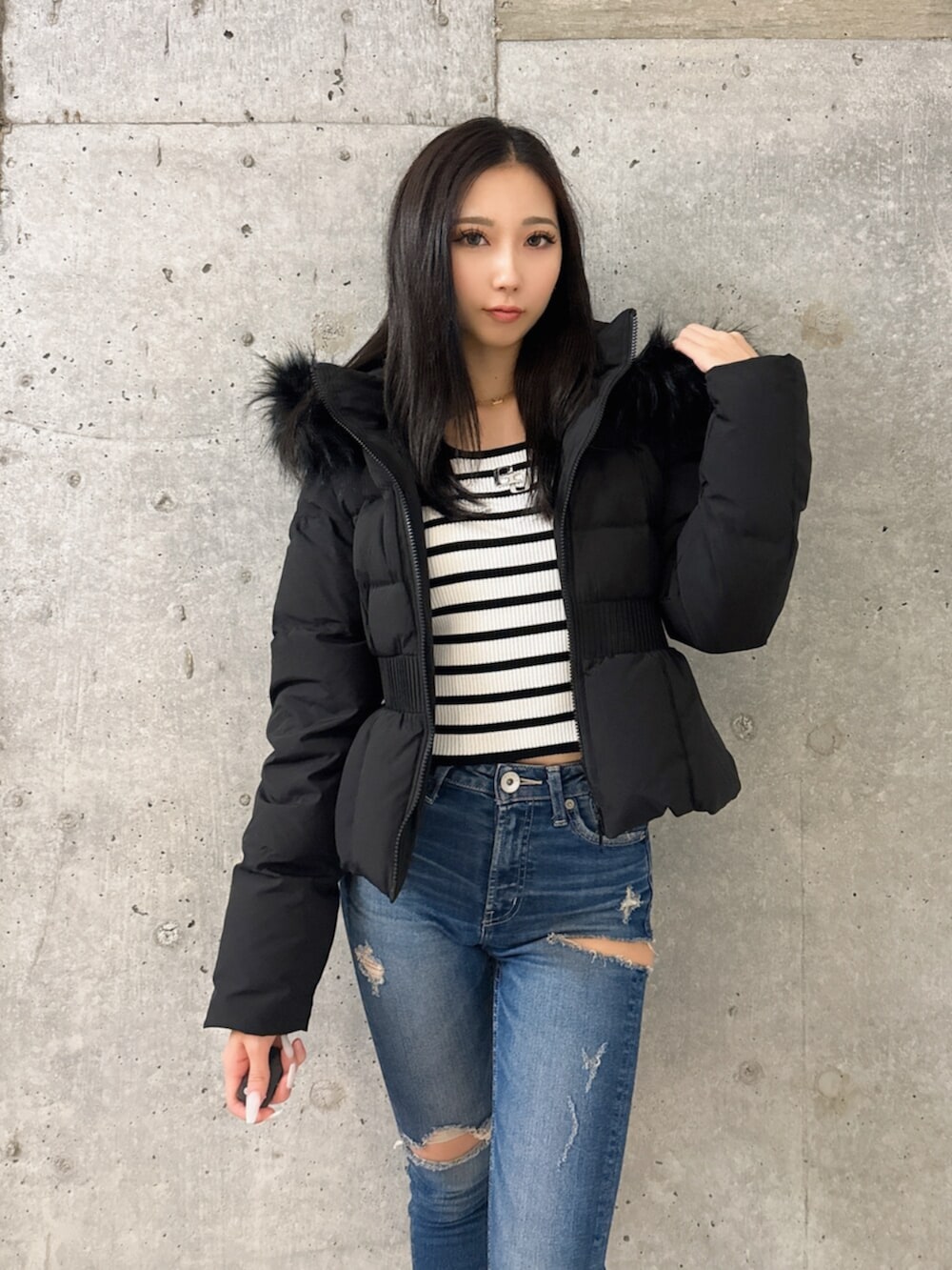 ブラック系のブーツ、その他のニット/セーター、ブルー系のデニムパンツを着用したレディースの秋コーディネートの4枚目の写真