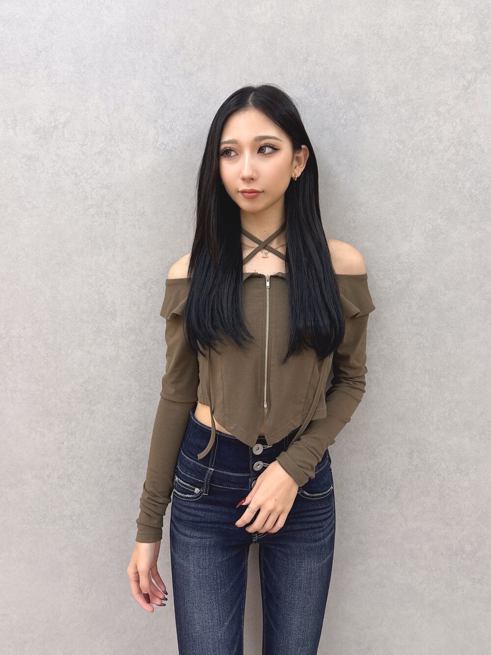 ブルー系のデニムパンツ、グリーン系のTシャツ/カットソー、ブラック系のサンダルを着用したレディースの夏コーディネートの4枚目の写真