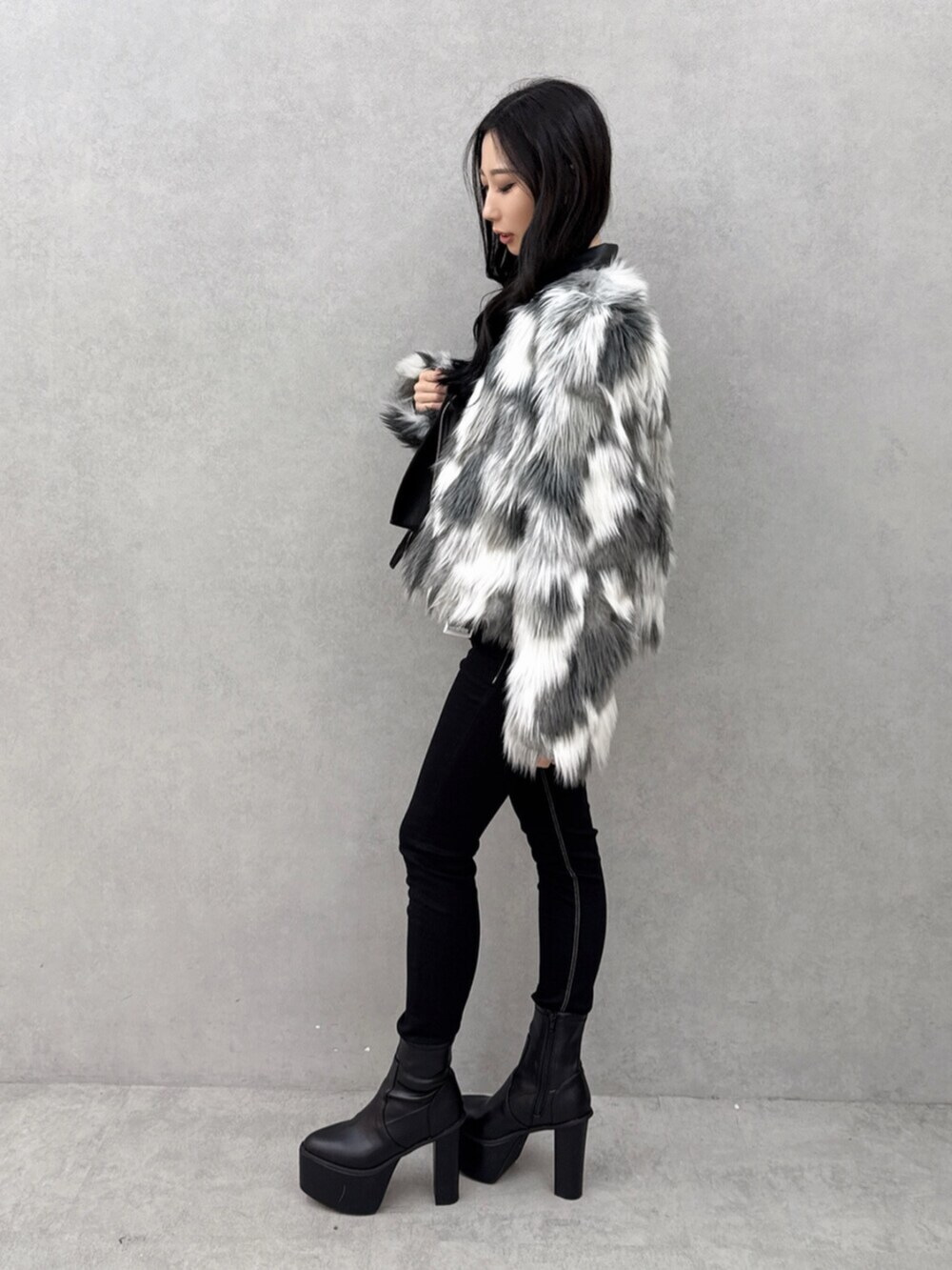 ブラック系のデニムパンツ、ブラック系のブーツ、ホワイト系のニット/セーターを着用したレディースの秋コーディネートの2枚目の写真