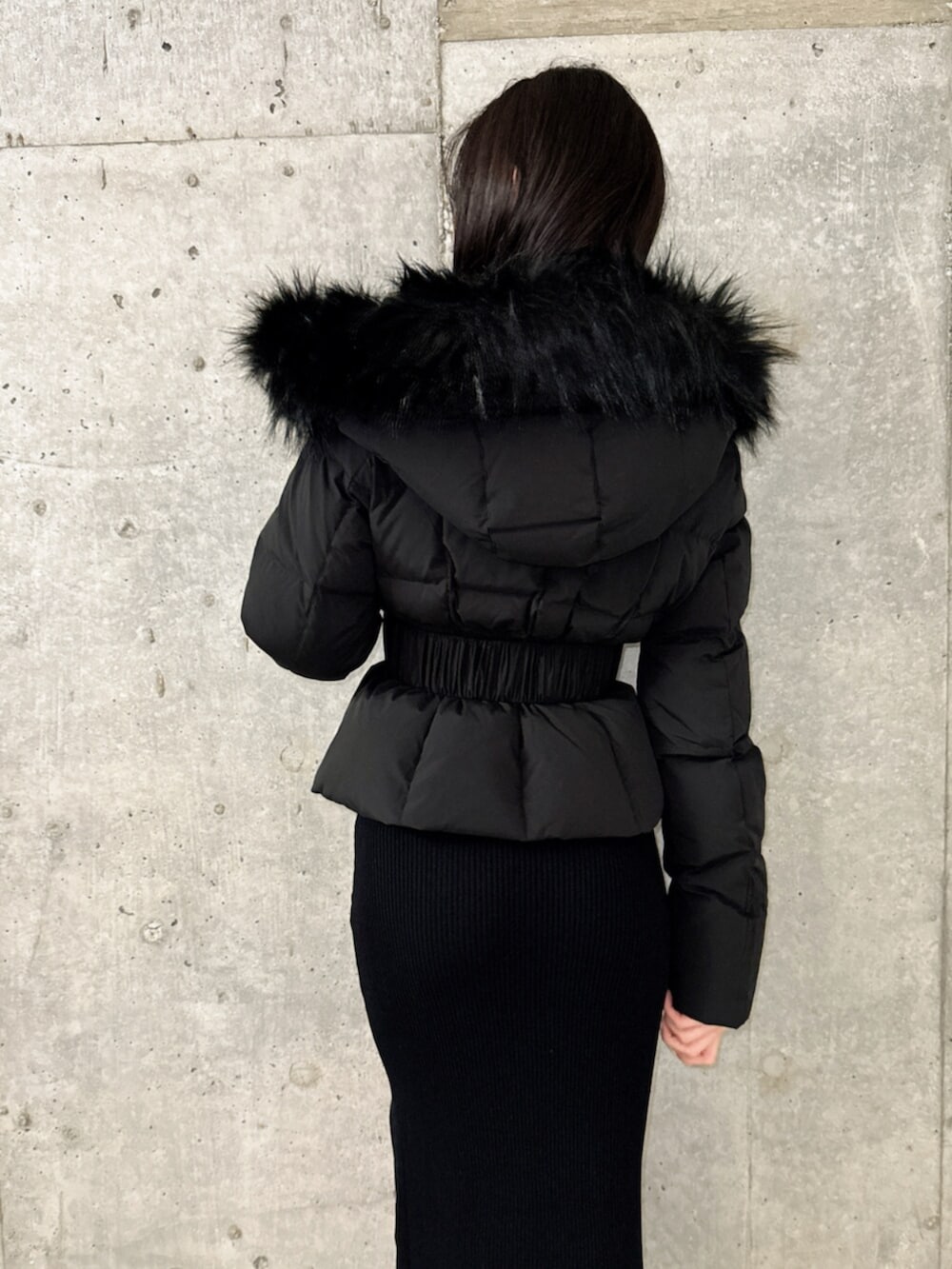 ブラック系のブーツ、ブラック系のダウンジャケット/コート、ブラック系のワンピースを着用したレディースの秋コーディネートの5枚目の写真