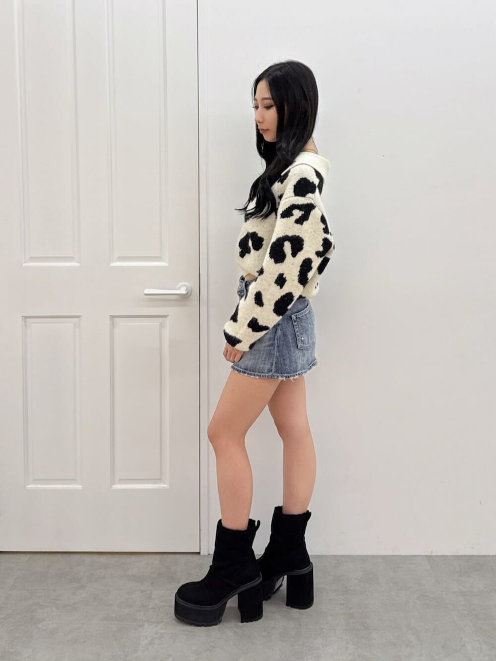 ブルー系のデニムスカート、その他のニット/セーター、ブラック系のブーツを着用したレディースの秋コーディネートの2枚目の写真