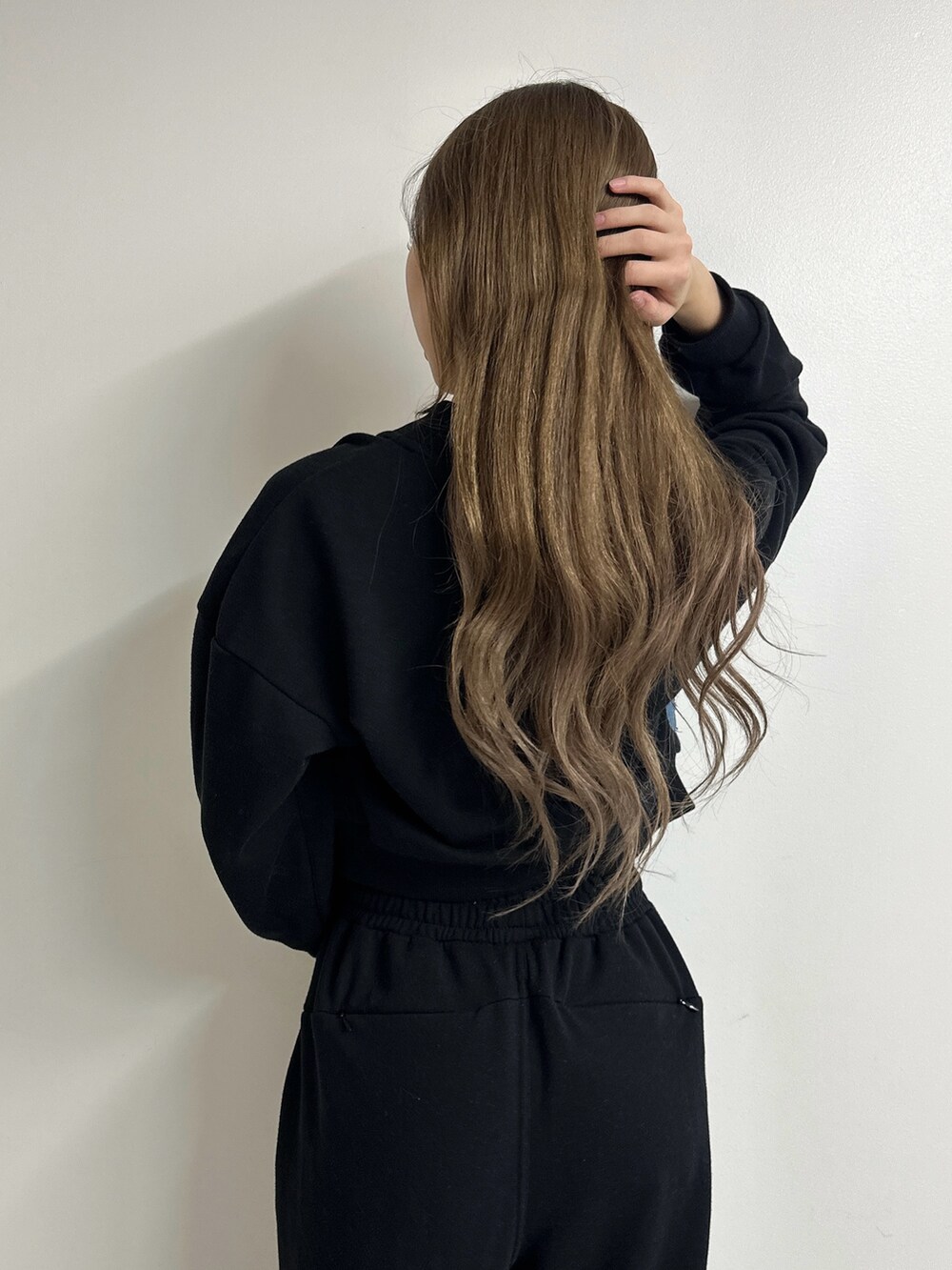 ブラック系のパンプス、ブラック系のスウェット、ホワイト系のキャミソールを着用したレディースの冬コーディネートの5枚目の写真