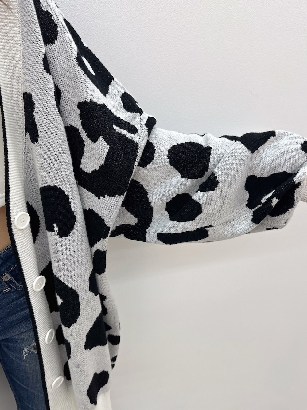 ブルー系のデニムパンツ、ブラック系のサンダル、ホワイト系のカーディガン/ボレロを着用したレディースの夏コーディネートの5枚目の写真