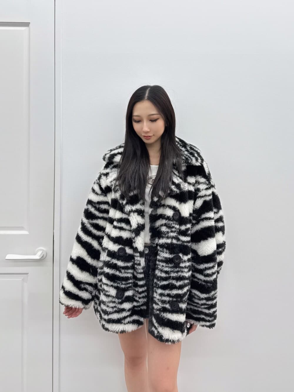 ブラック系のブーツ、ブラック系のデニムスカート、その他のブルゾンを着用したレディースの秋コーディネートの4枚目の写真