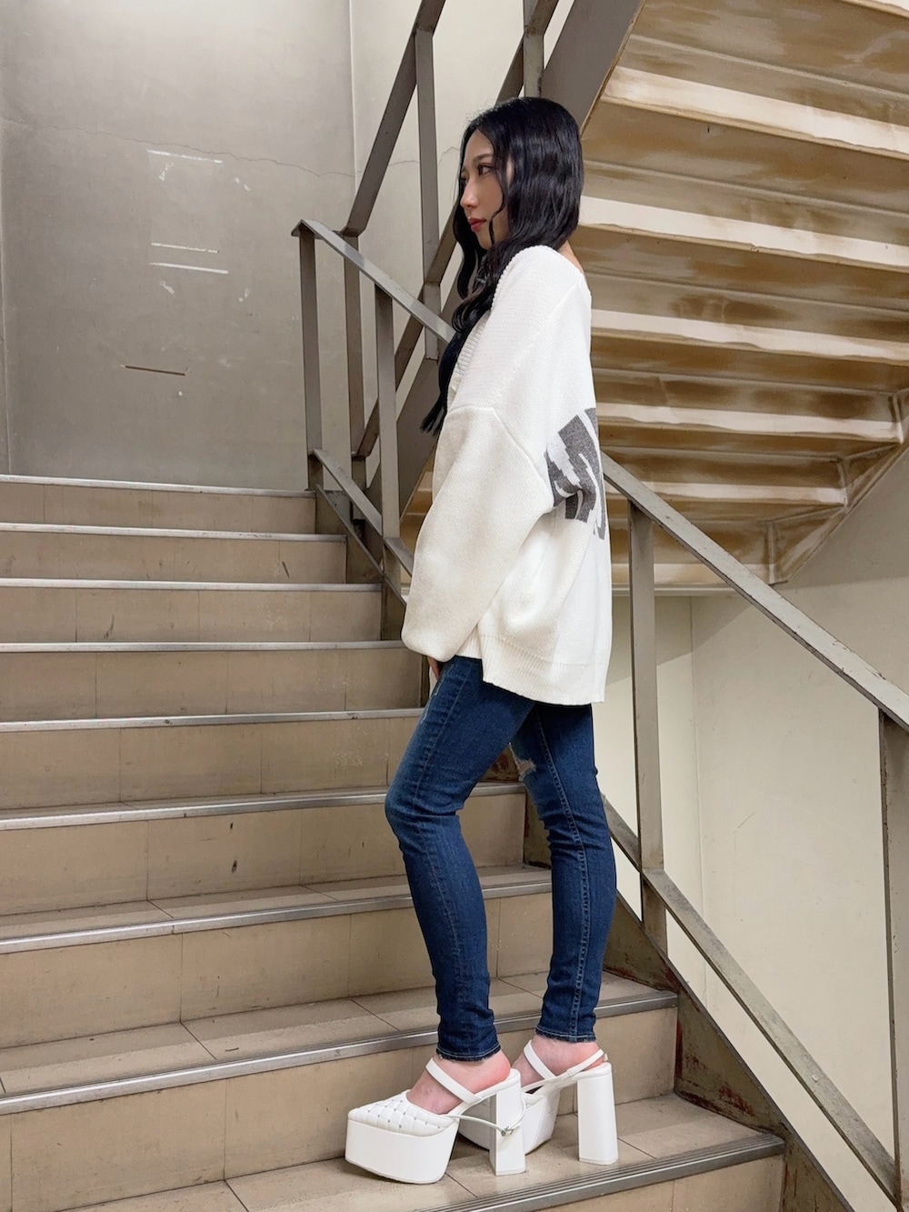 ブルー系のデニムパンツ、ブラック系のキャミソール、ホワイト系のカーディガン/ボレロを着用したレディースの冬コーディネートの2枚目の写真