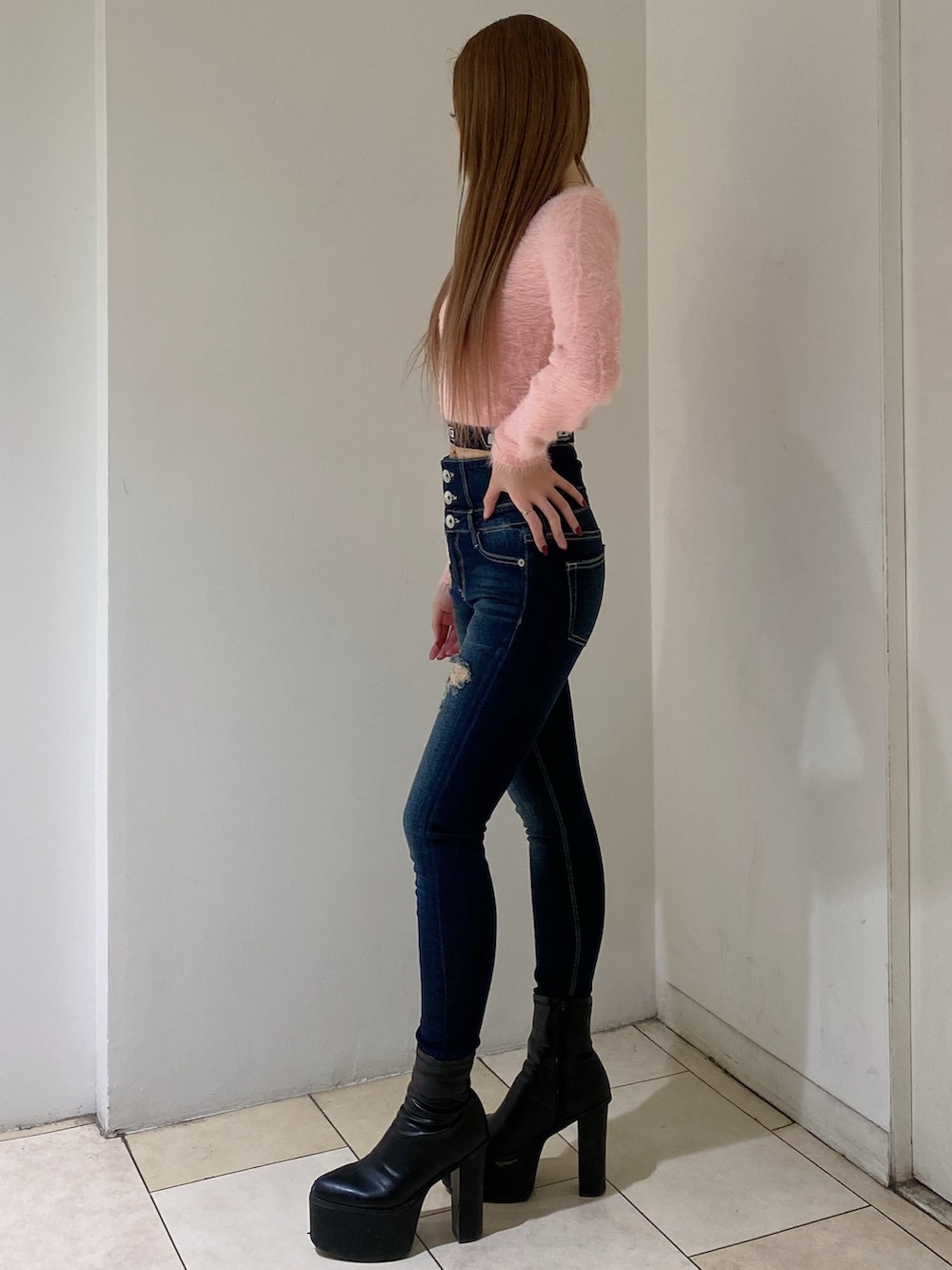 ピンク系のニット/セーター、ブルー系のデニムパンツ、ブラック系のブーツを着用したレディースの冬コーディネートの2枚目の写真